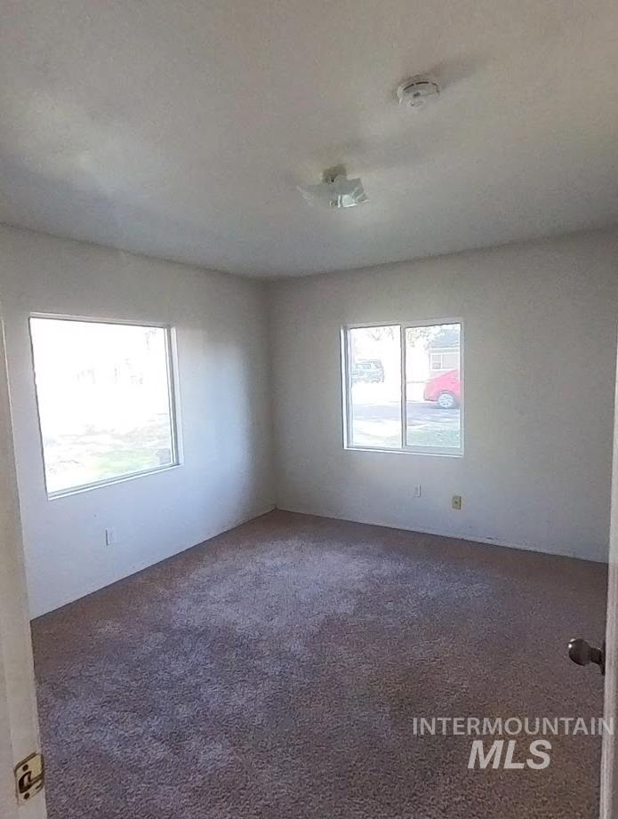 Spare room with dark colored carpet