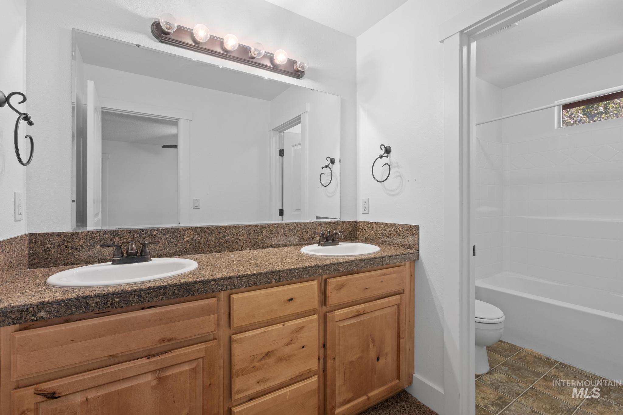 Full bathroom with double vanity and tub / shower combination