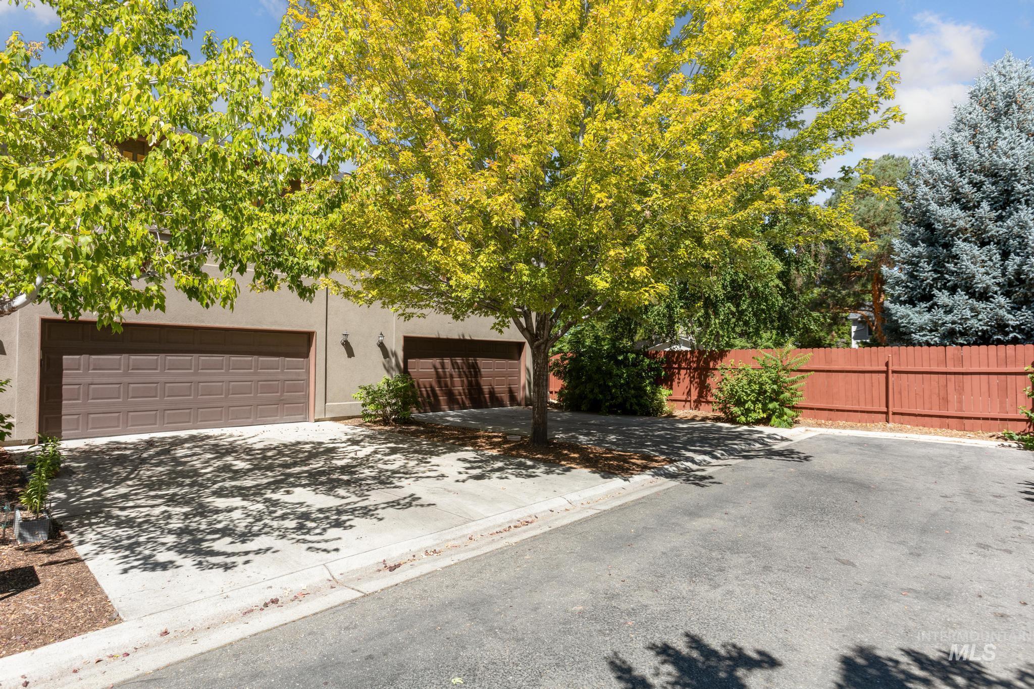 Obstructed view of property with a garage, concrete driveway, and stucco siding