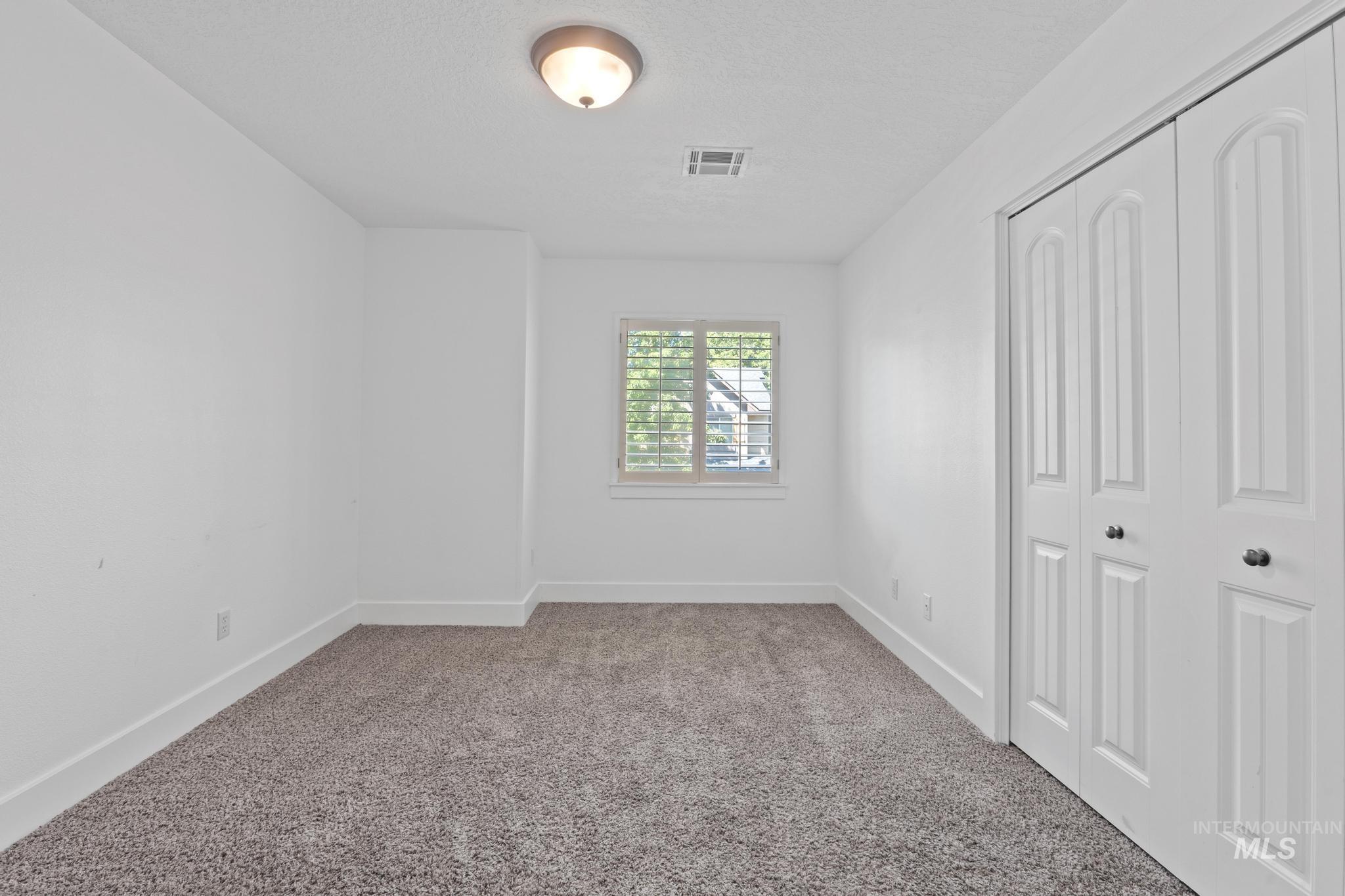 Unfurnished bedroom featuring carpet and a closet