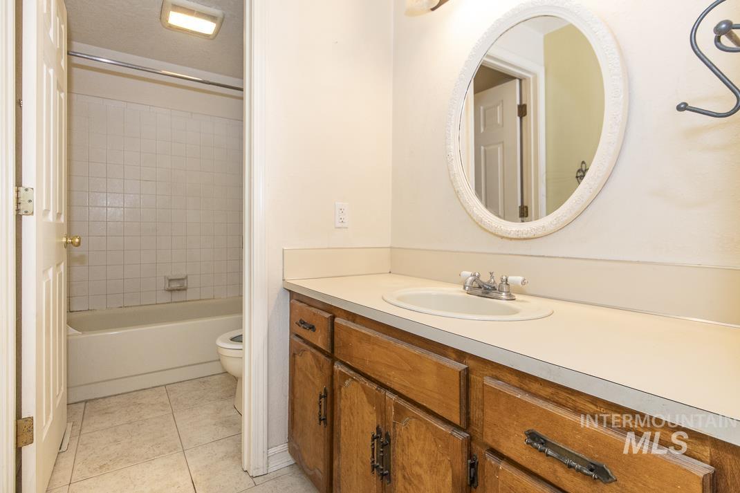 Bathroom with vanity, light tile patterned floors, and  shower combination