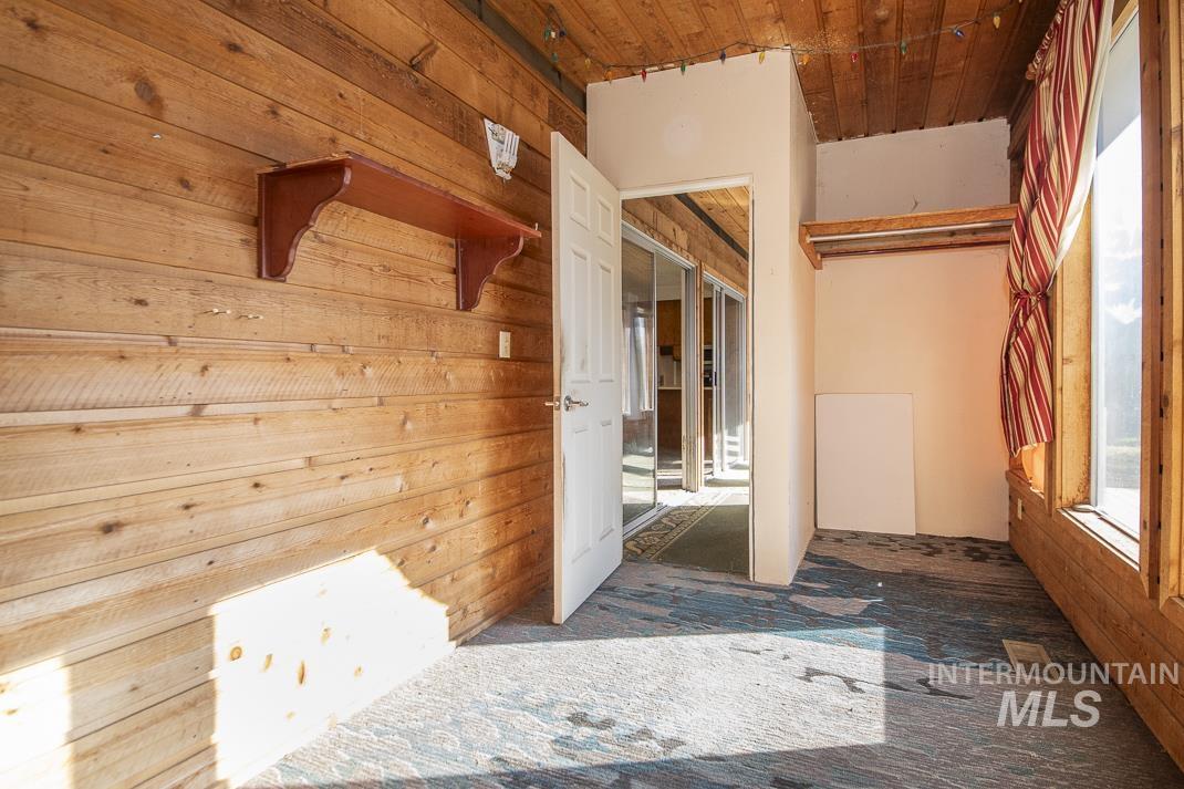 Hallway featuring wood walls and carpet