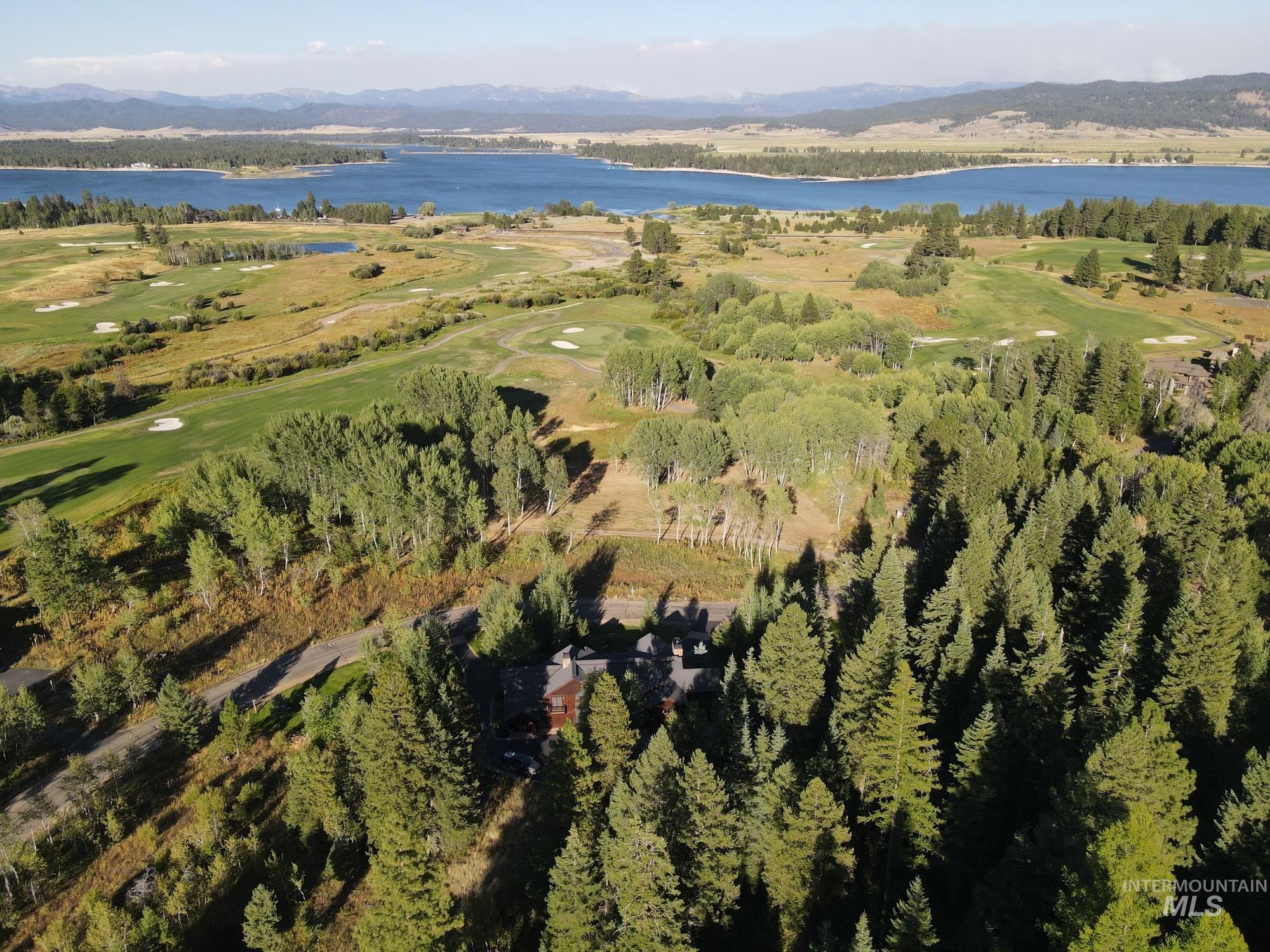 Aerial view of property and surrounding area with a water and mountain view and a local golf course