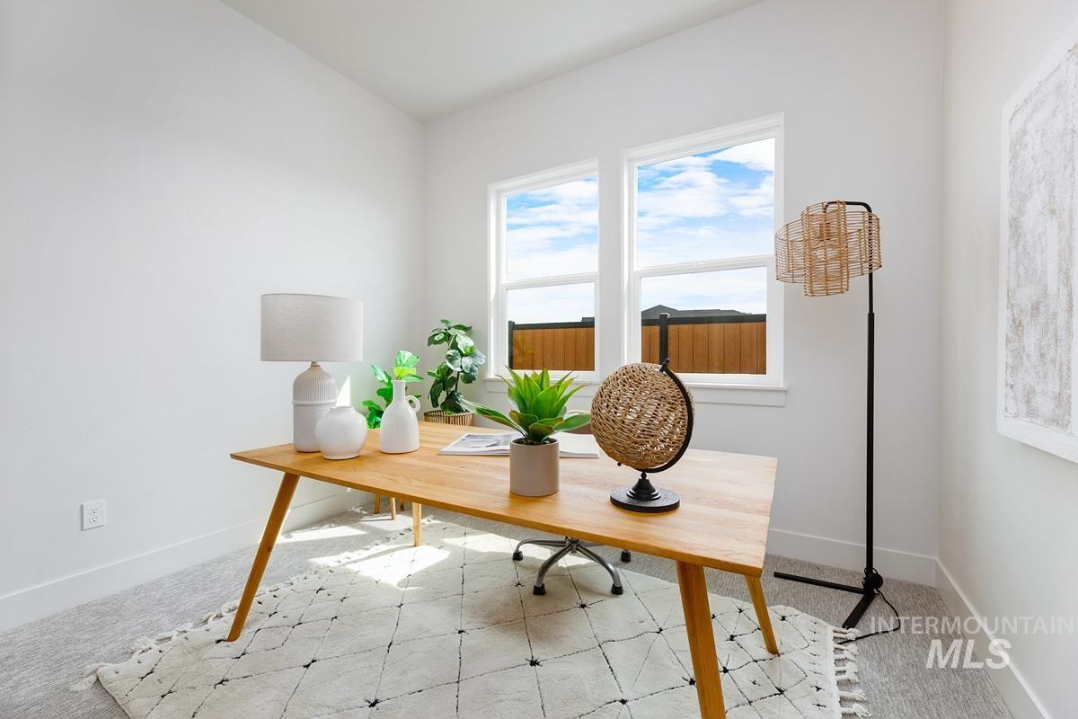 Office area featuring baseboards and light carpet