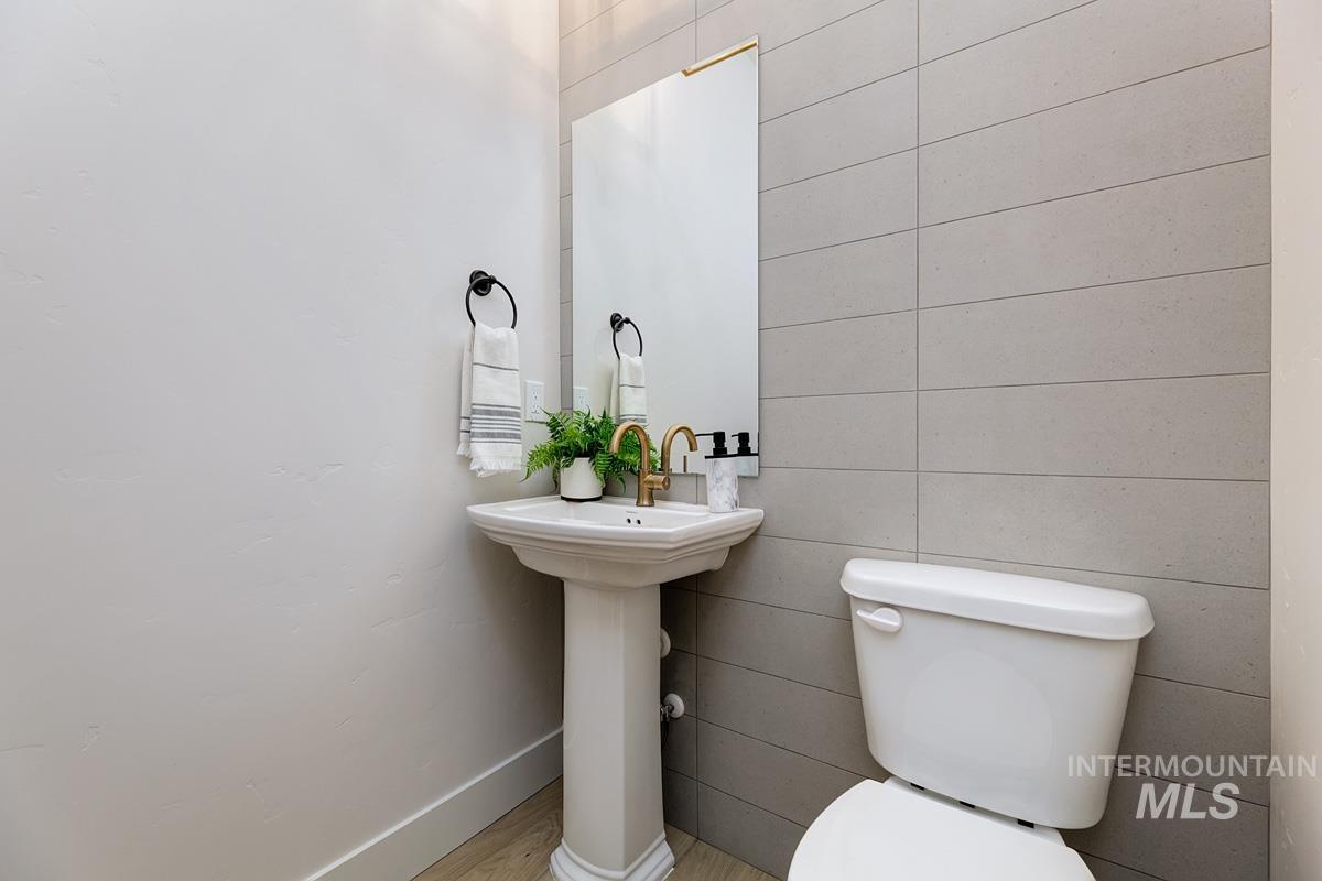 Half bath featuring baseboards and wood finished floors