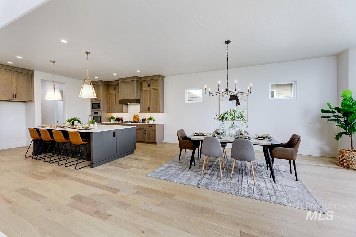 Dining room with light wood-style floors and suspended lighting