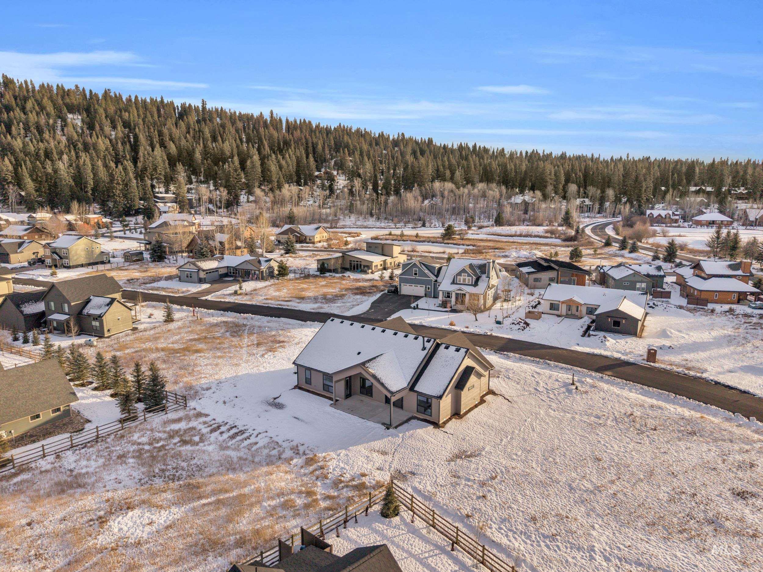Snowy aerial view featuring a residential view and a view of trees