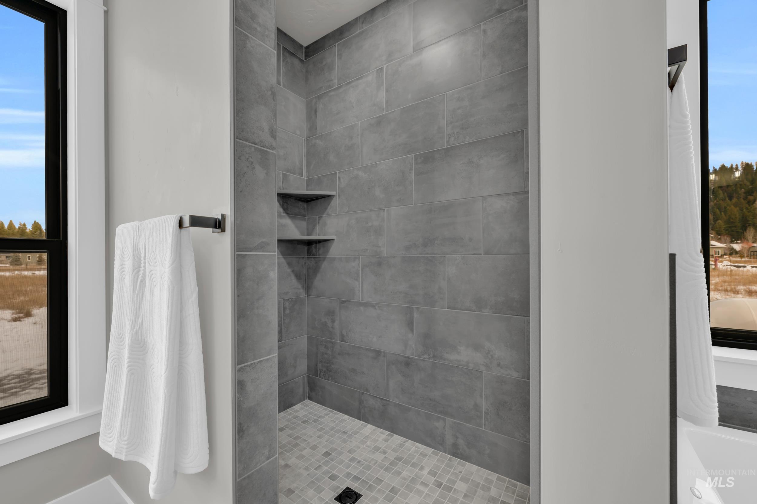 Full bath with healthy amount of natural light and tiled shower