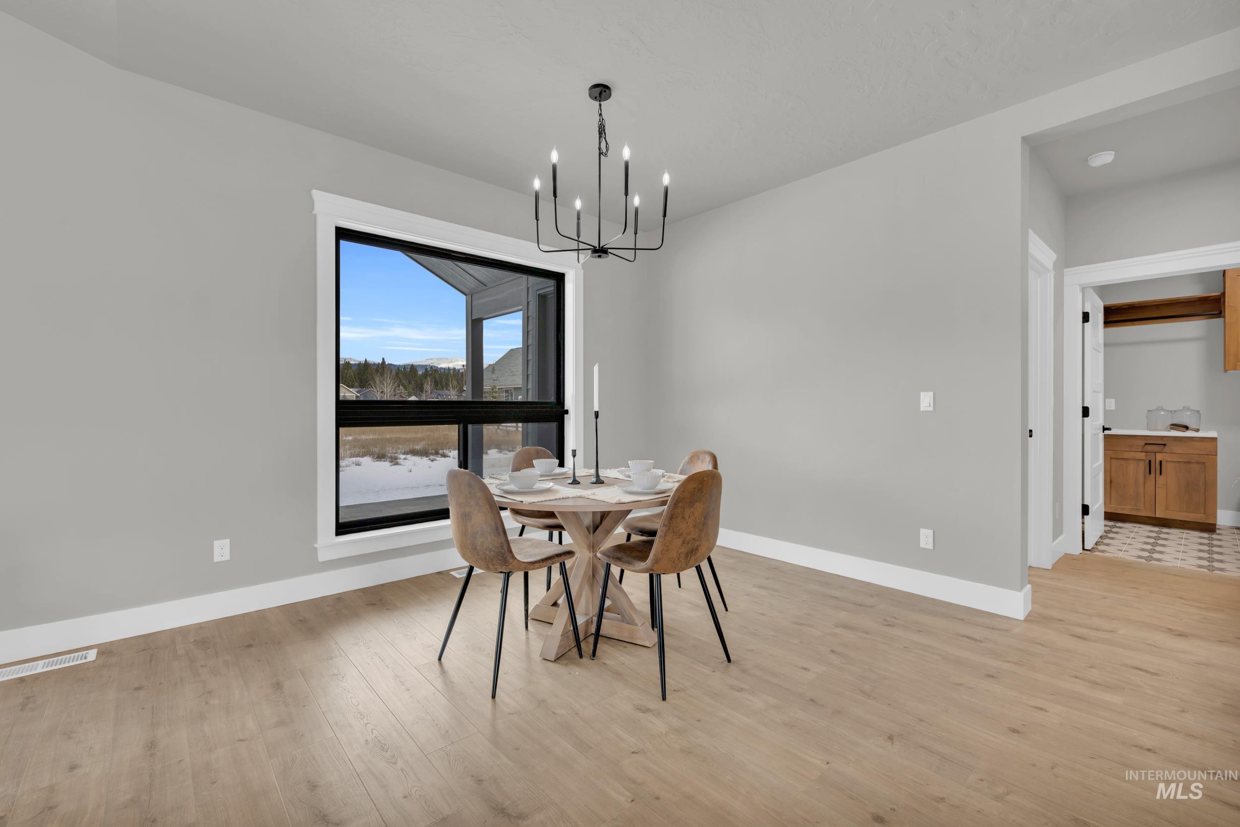 Dining space with light wood-style floors and a chandelier