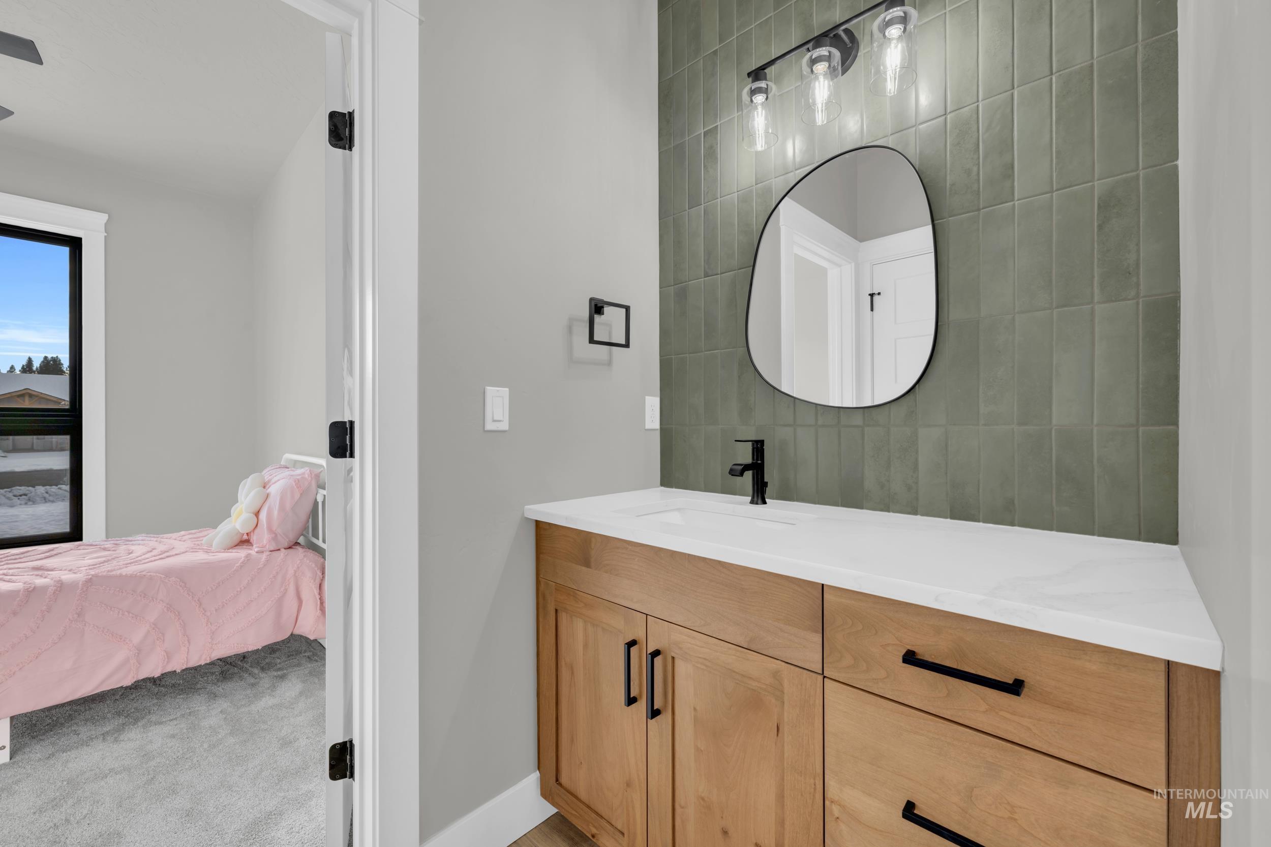 Bathroom featuring ensuite bathroom, vanity, and light colored carpet