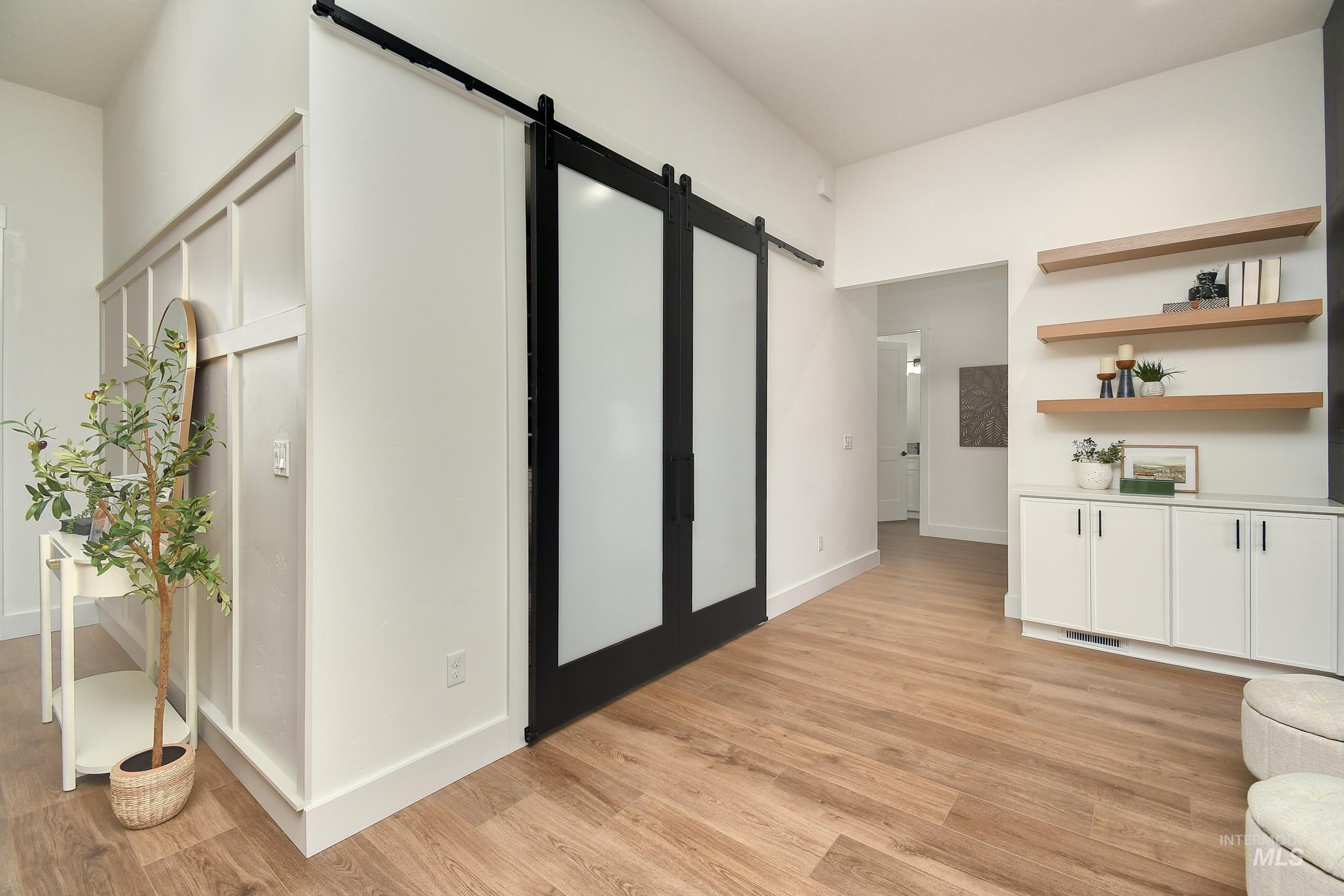 Corridor with a barn door and light wood-style flooring
