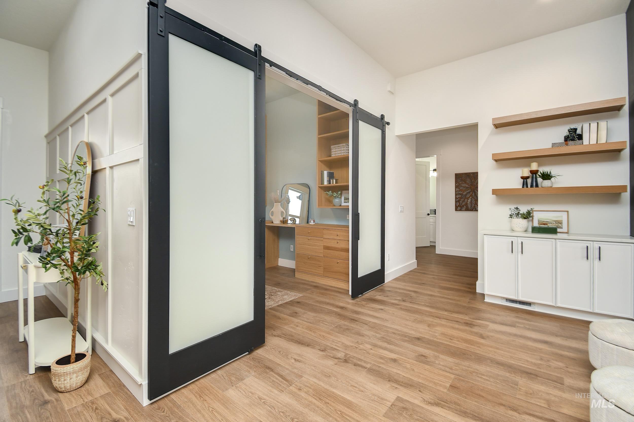 Corridor featuring a barn door and light wood-style flooring