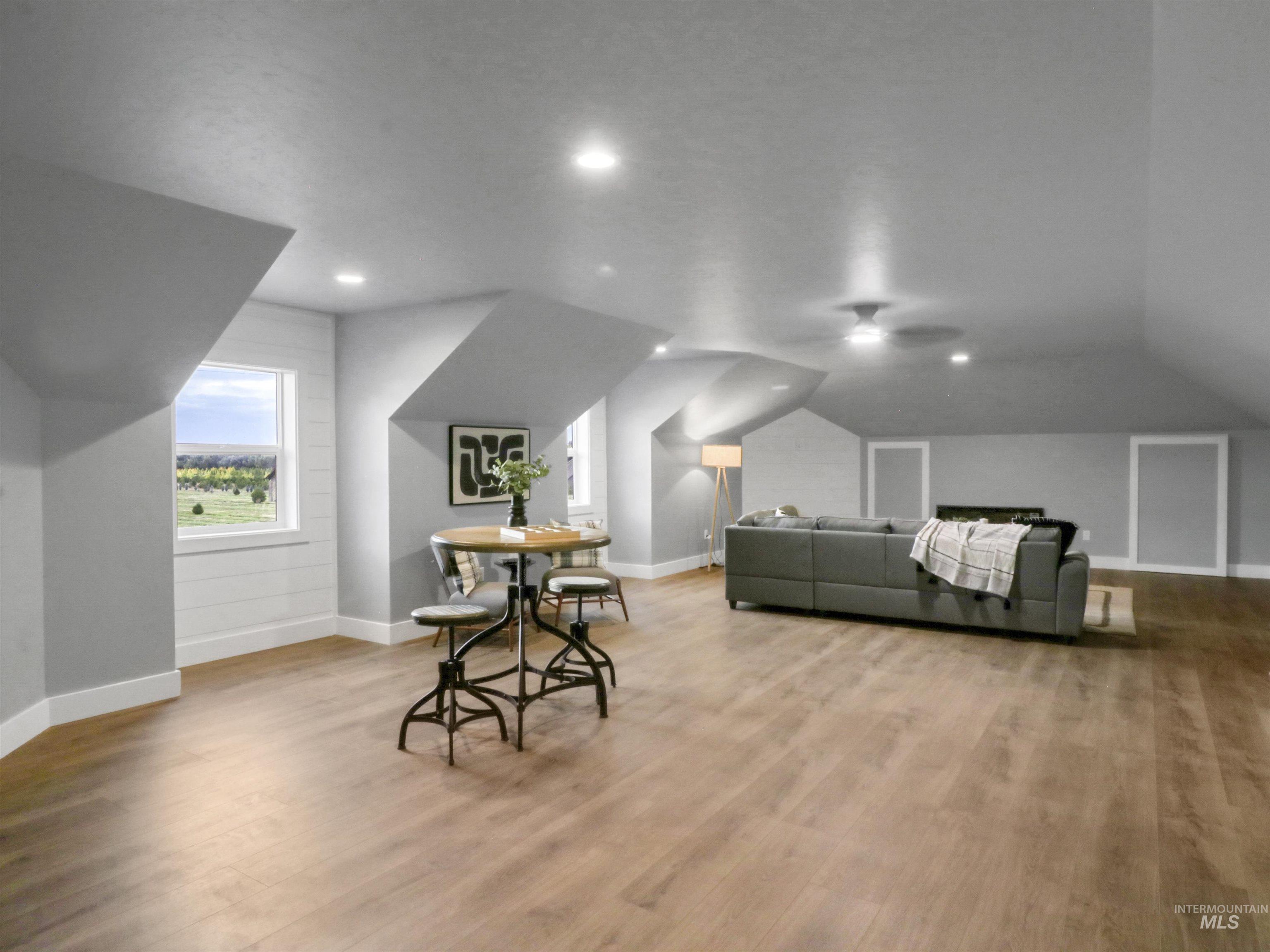 Bonus room with light wood-type flooring, vaulted ceiling, and recessed lighting