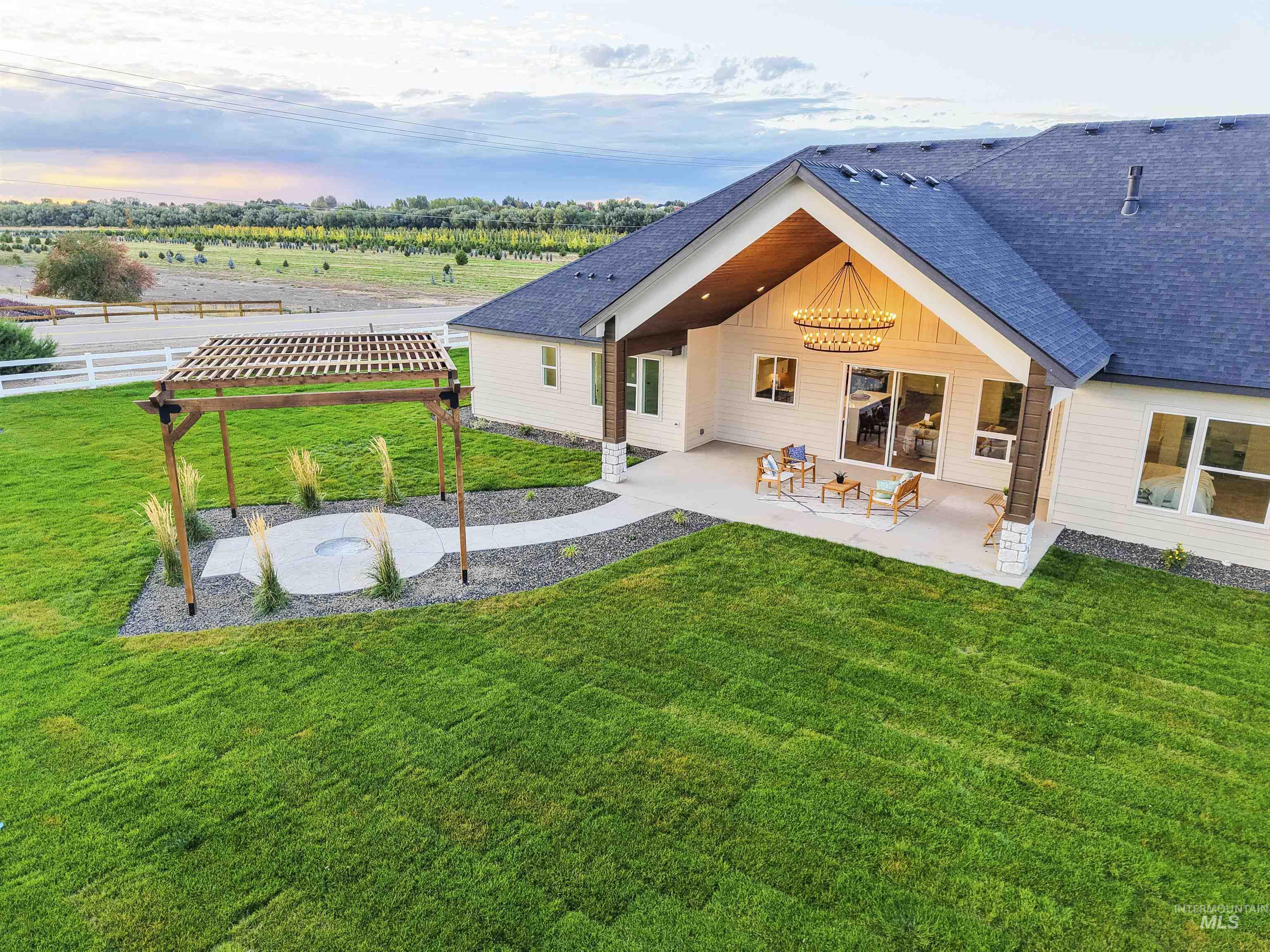 Back of house with a patio and roof with shingles