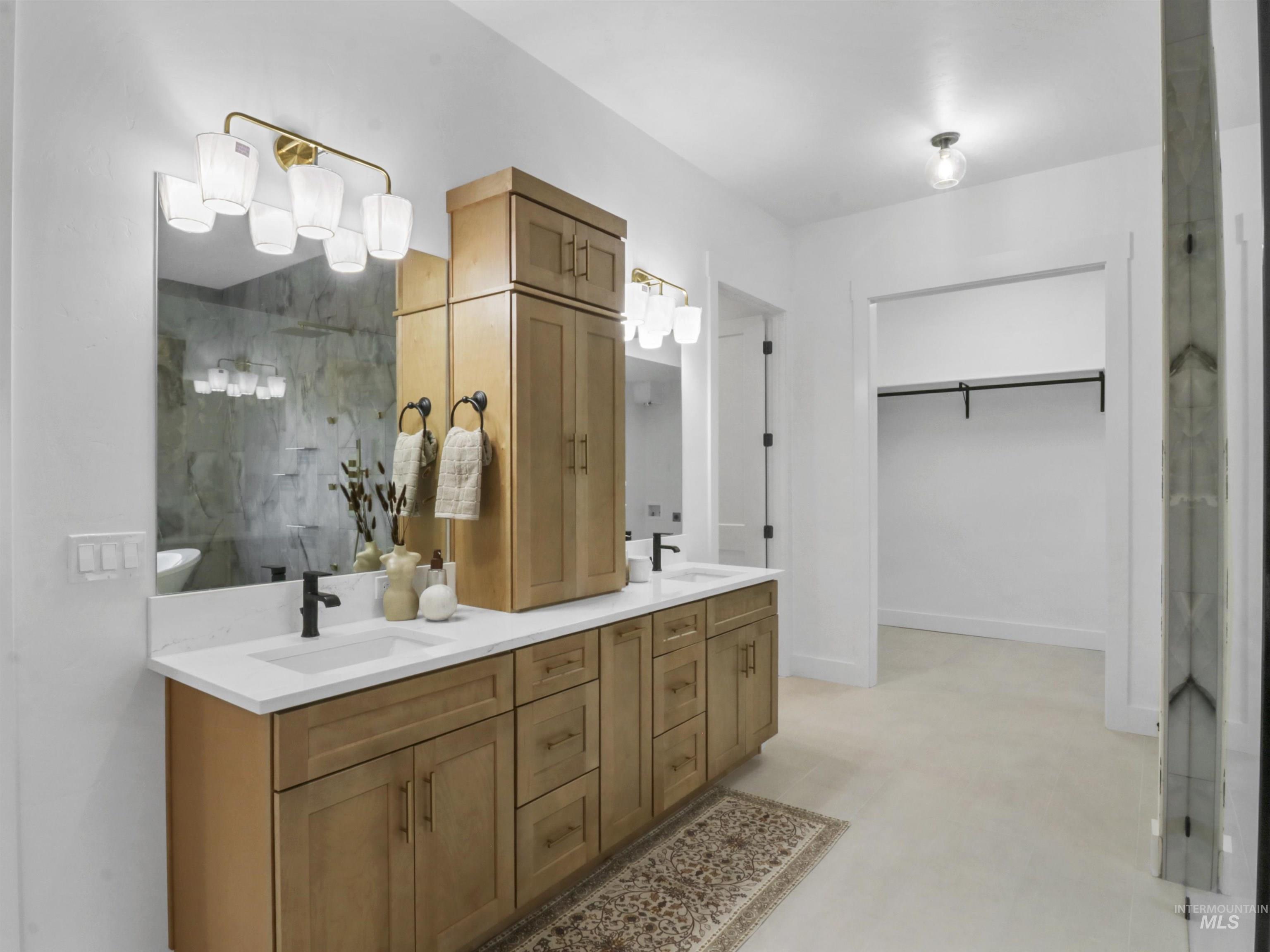 Bathroom with double vanity, a spacious closet, and a shower with door