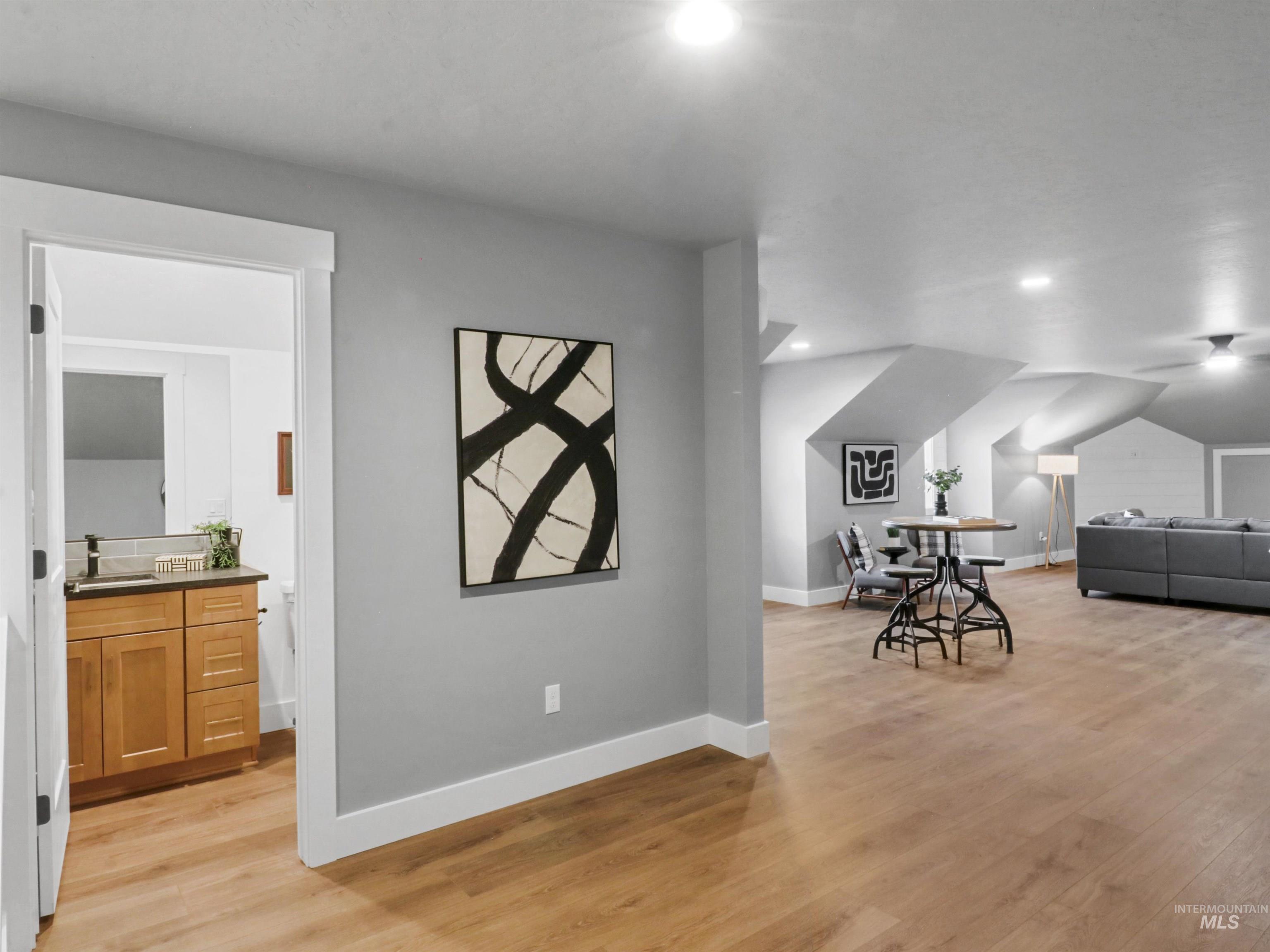 Bedroom featuring light wood-style floors, ensuite bathroom, and recessed lighting