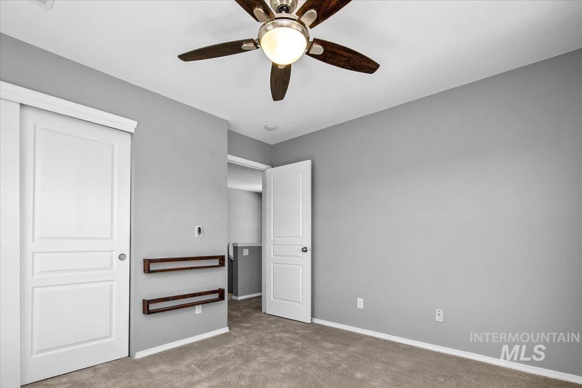 Unfurnished bedroom with carpet floors, ceiling fan, and a closet