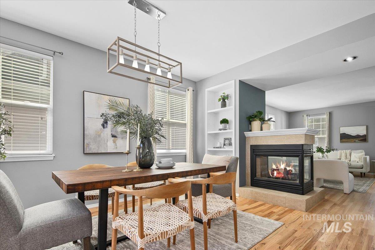 Dining room with plenty of natural light, wood finished floors, a fireplace, and built in features