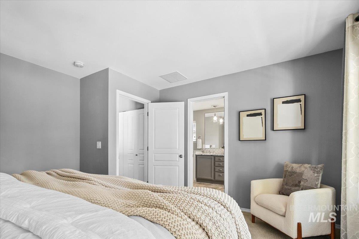 Primary Bedroom featuring a closet, ensuite bath, and carpet
