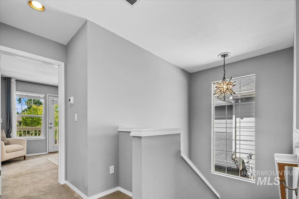 Corridor featuring an upstairs landing and carpet floors