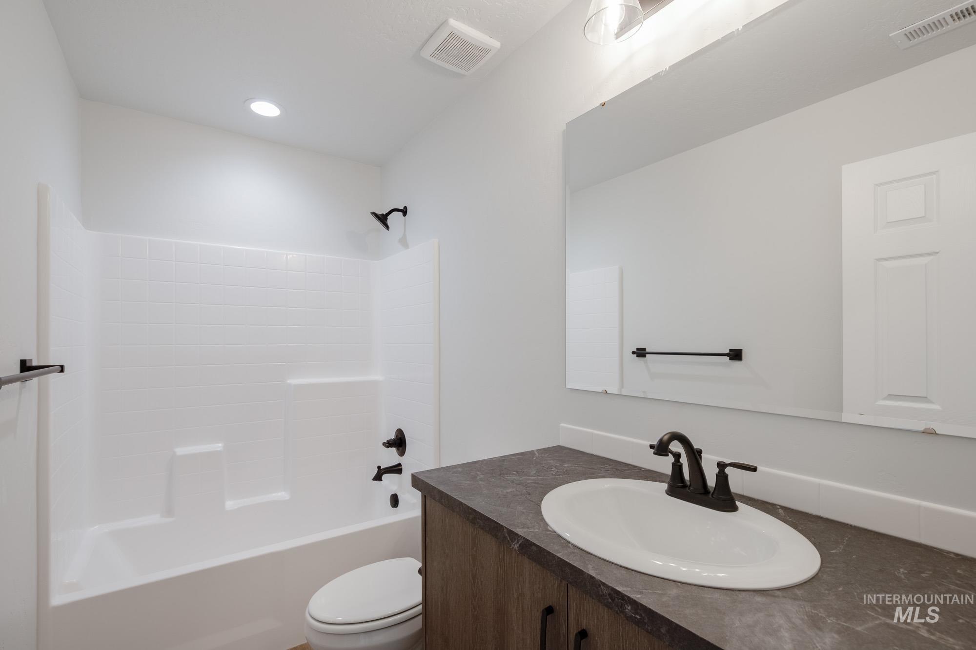 Bathroom with vanity, shower / tub combination, and recessed lighting