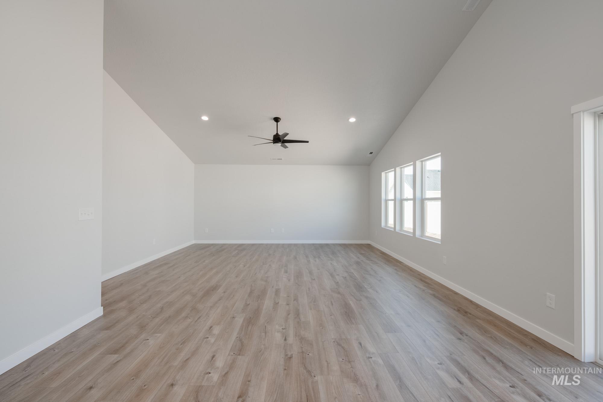 Unfurnished room featuring vaulted ceiling, light wood-type flooring, recessed lighting, and ceiling fan