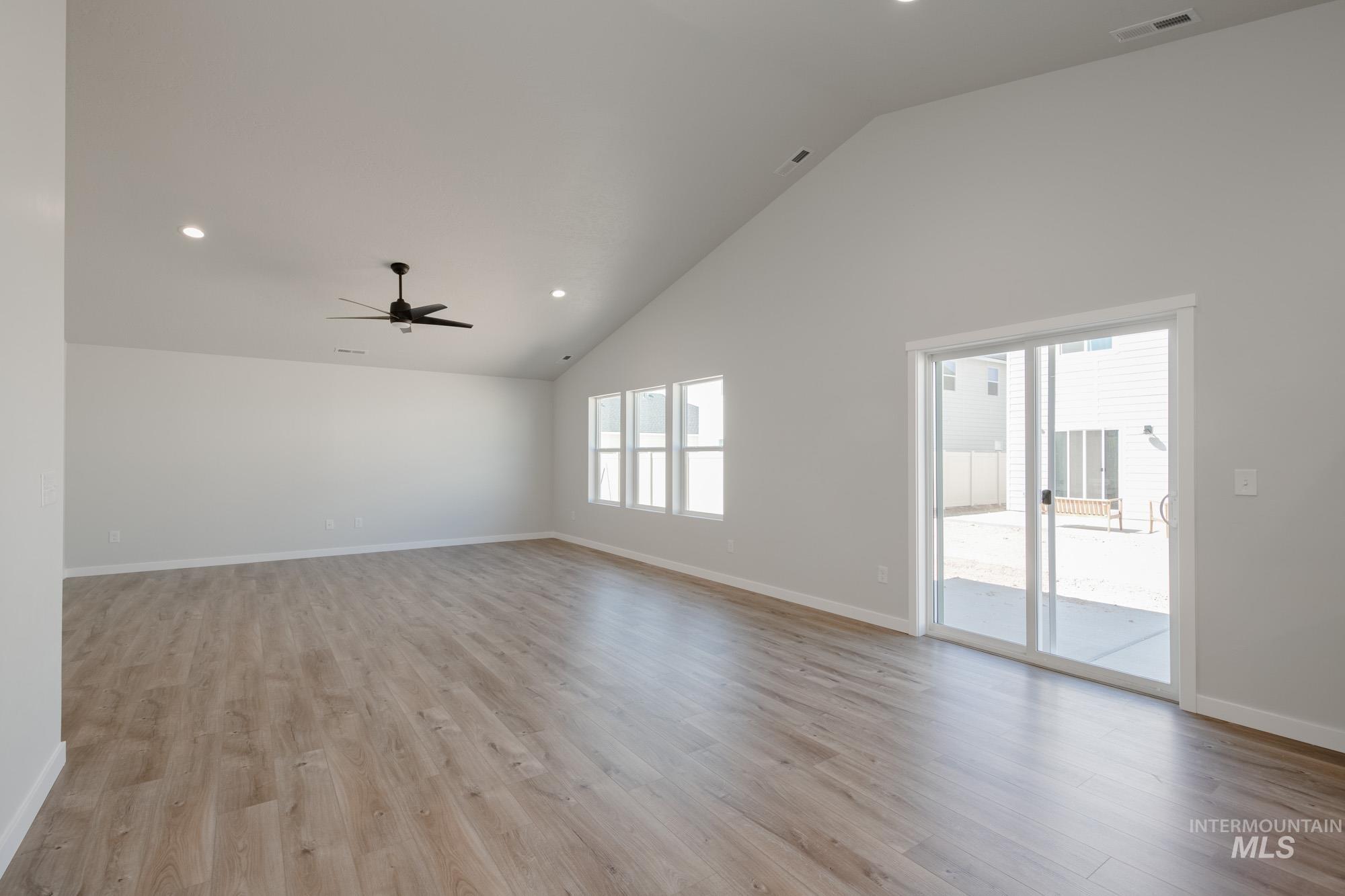 Unfurnished room featuring high vaulted ceiling, recessed lighting, light wood-style flooring, and ceiling fan