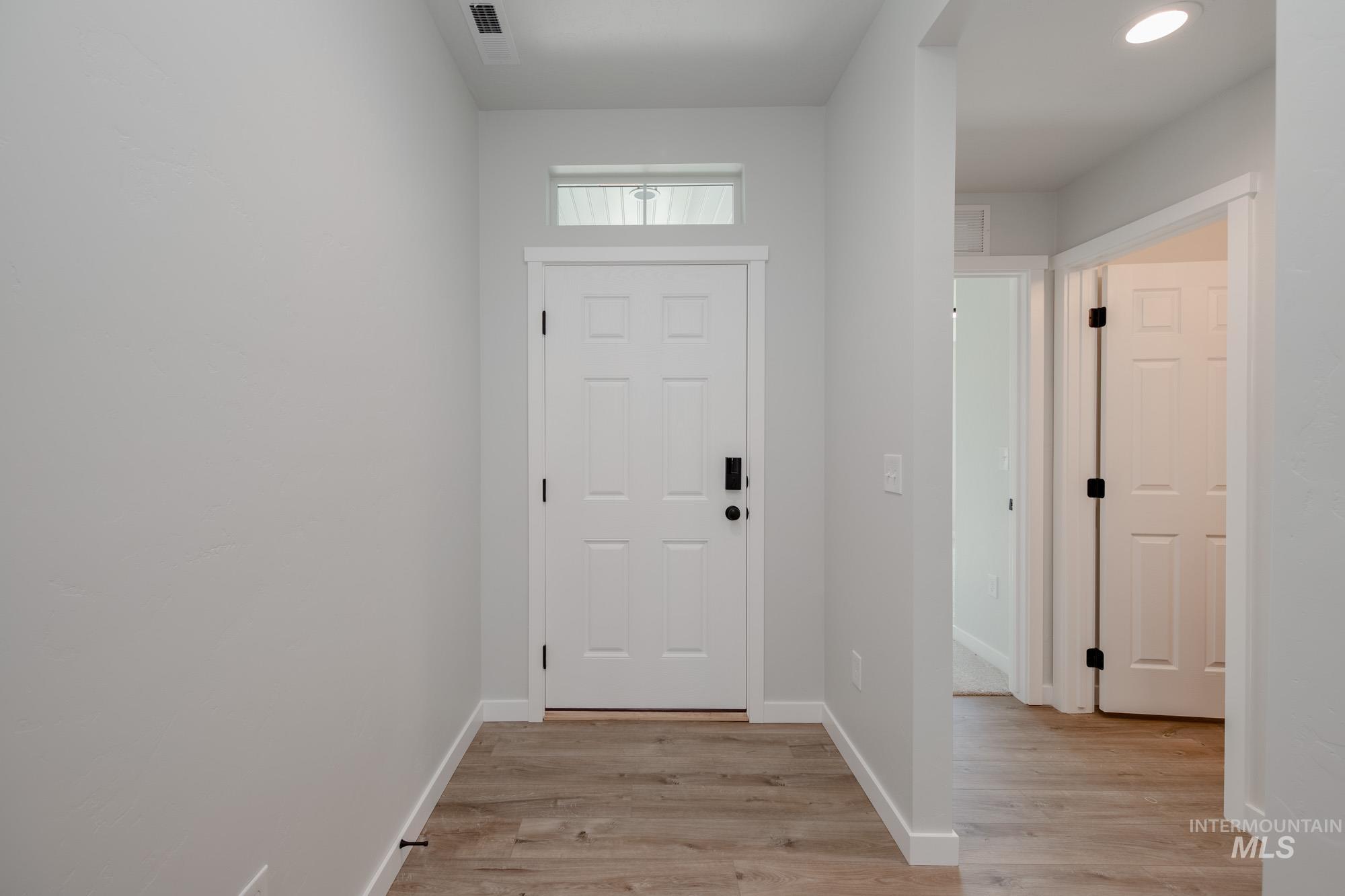 Entrance foyer with light wood finished floors and recessed lighting