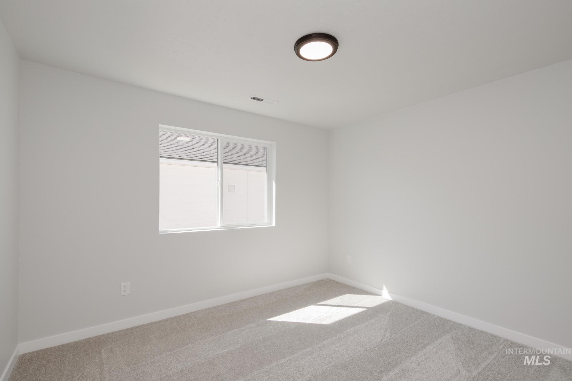 Empty room featuring carpet and baseboards
