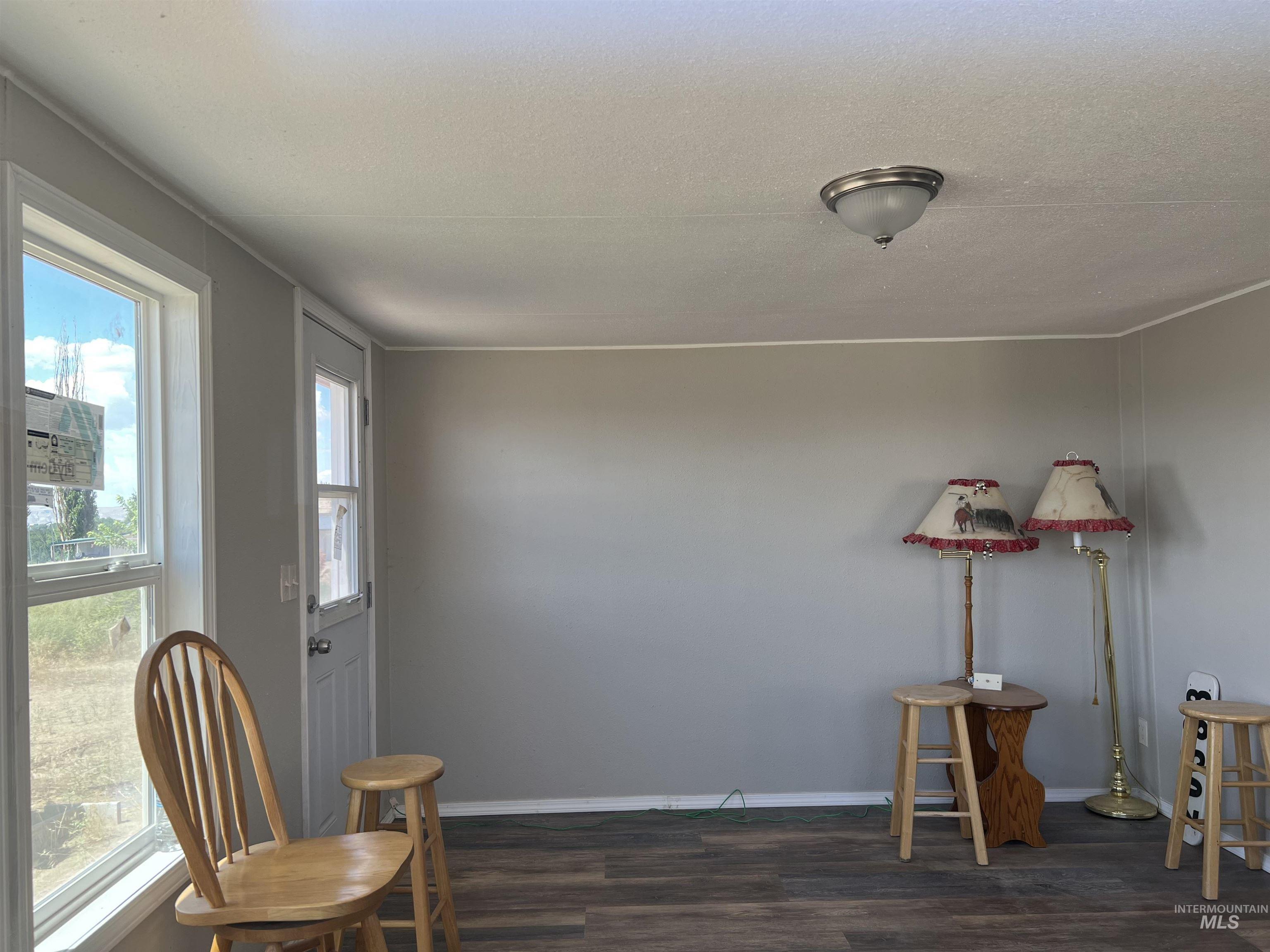Sitting room with dark wood-type flooring and baseboards