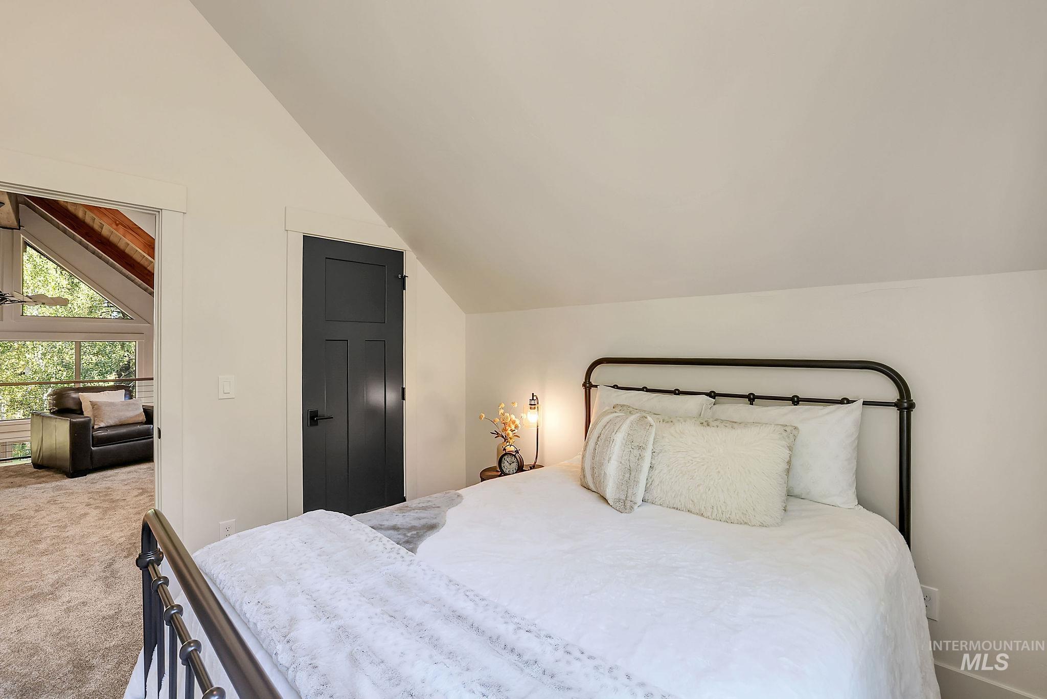 Bedroom featuring carpet flooring and vaulted ceiling