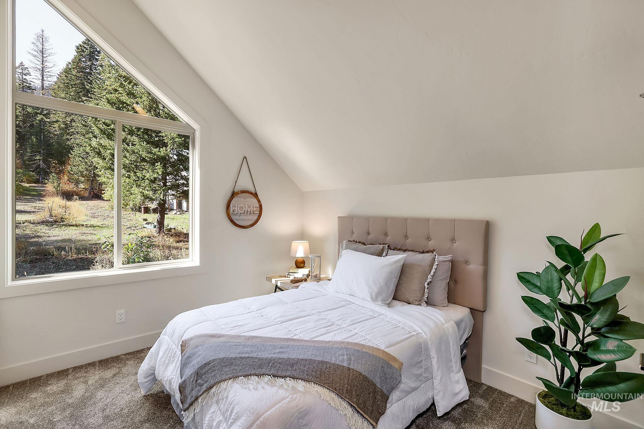 Bedroom with lofted ceiling and carpet flooring
