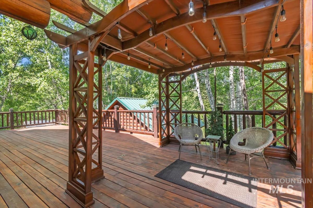 Wooden terrace featuring view of wooded area