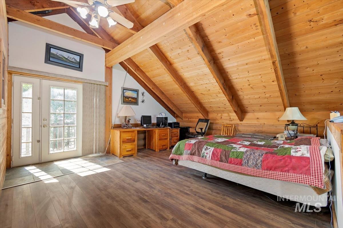 Bedroom with hardwood / wood-style flooring, a wooden ceiling with exposed beams, access to outside, ceiling fan, and a desk