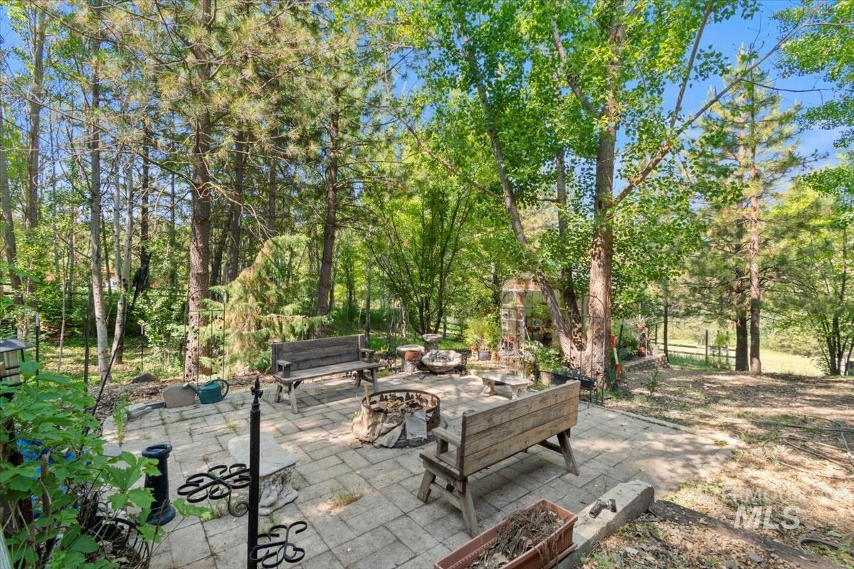 View of patio / terrace with a fire pit and view of scattered trees