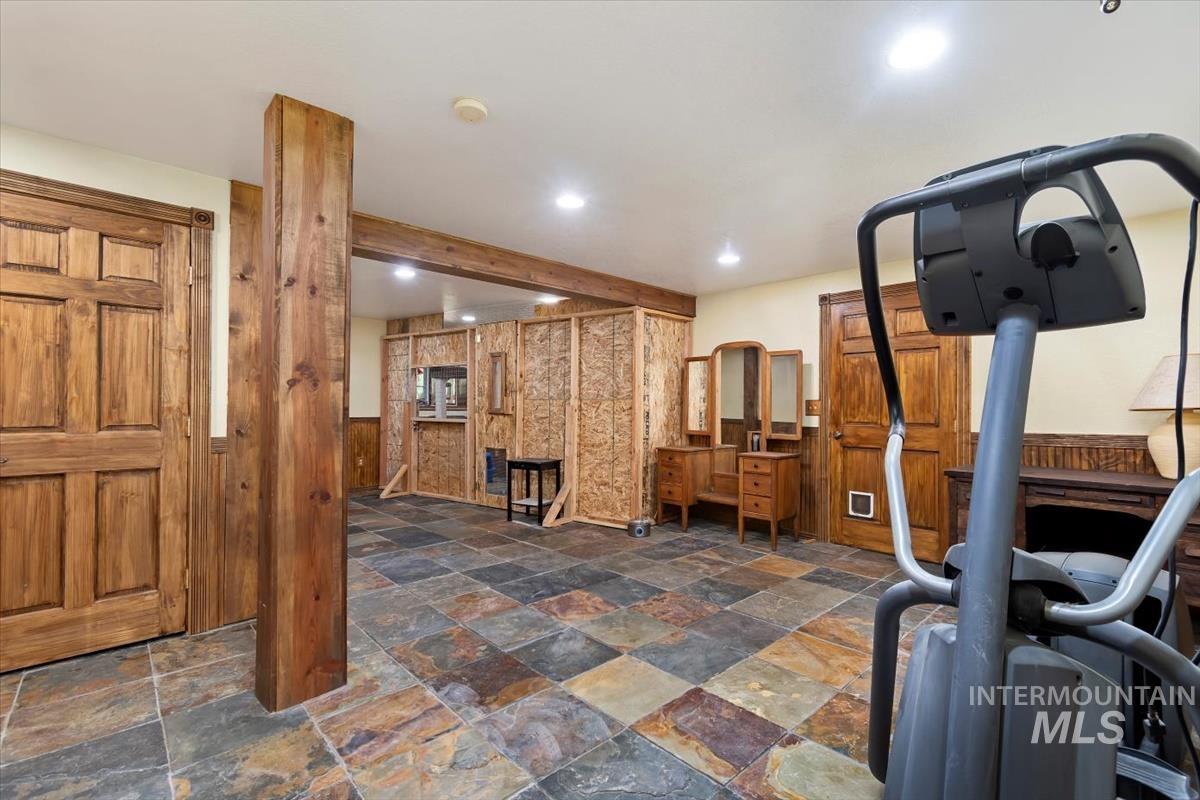 Exercise room with wood walls, a wainscoted wall, and recessed lighting