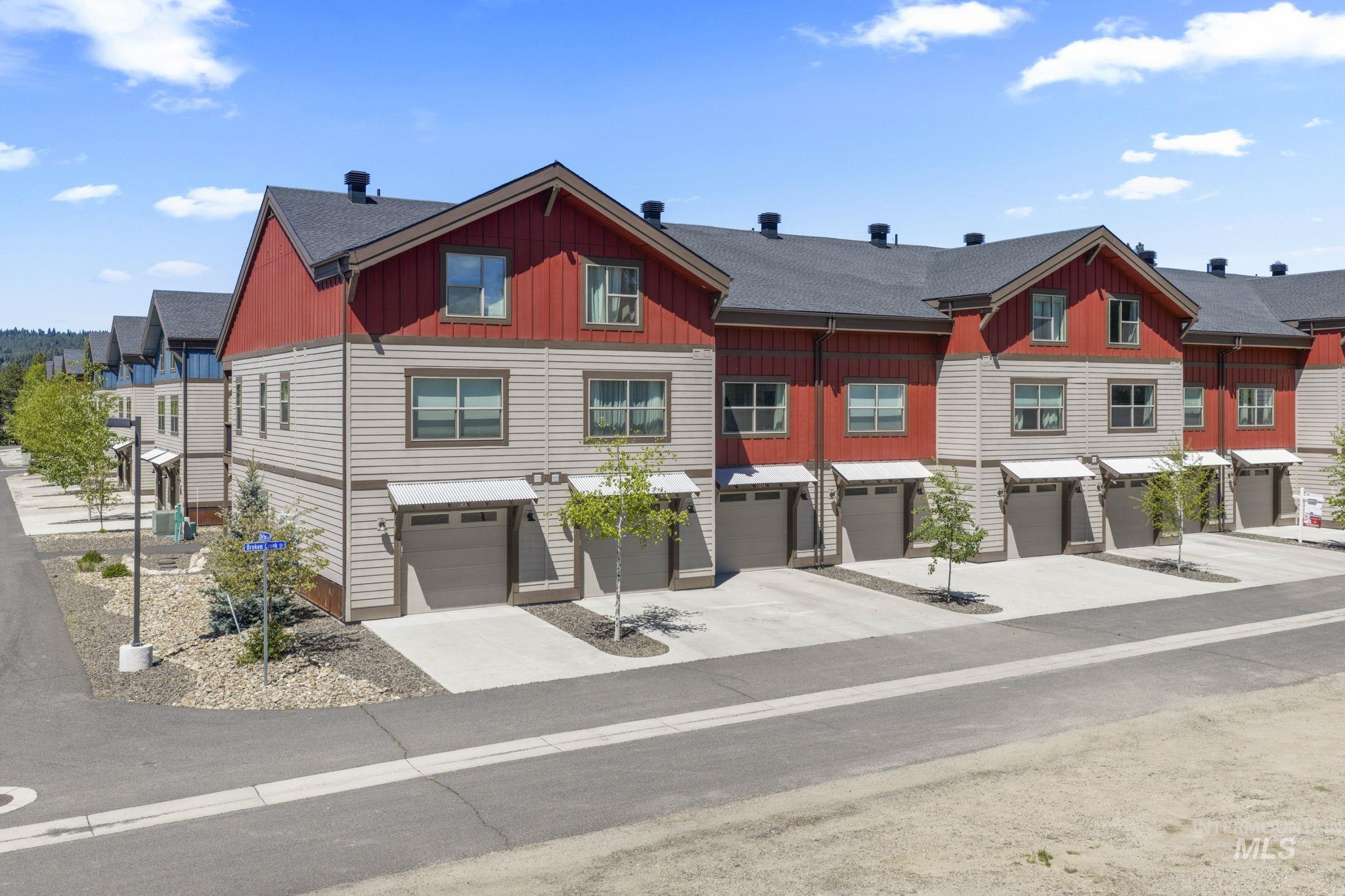 Contemporary townhome complex featuring multi-level units with attached garages, individual driveways, and a consistent architectural style
