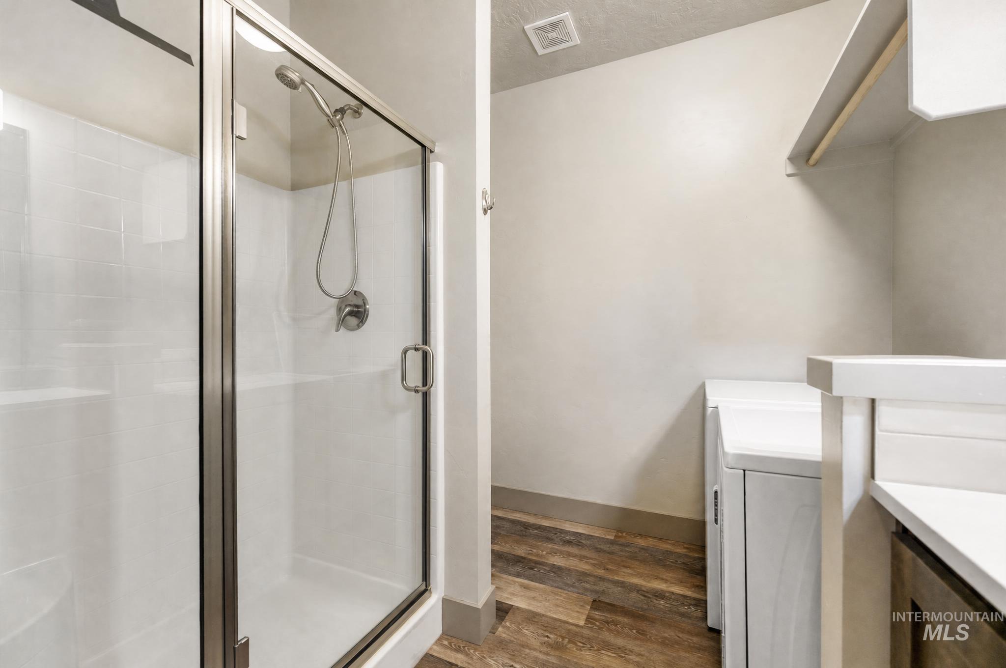 Walk-in shower with clear glass enclosure and subway tile surround