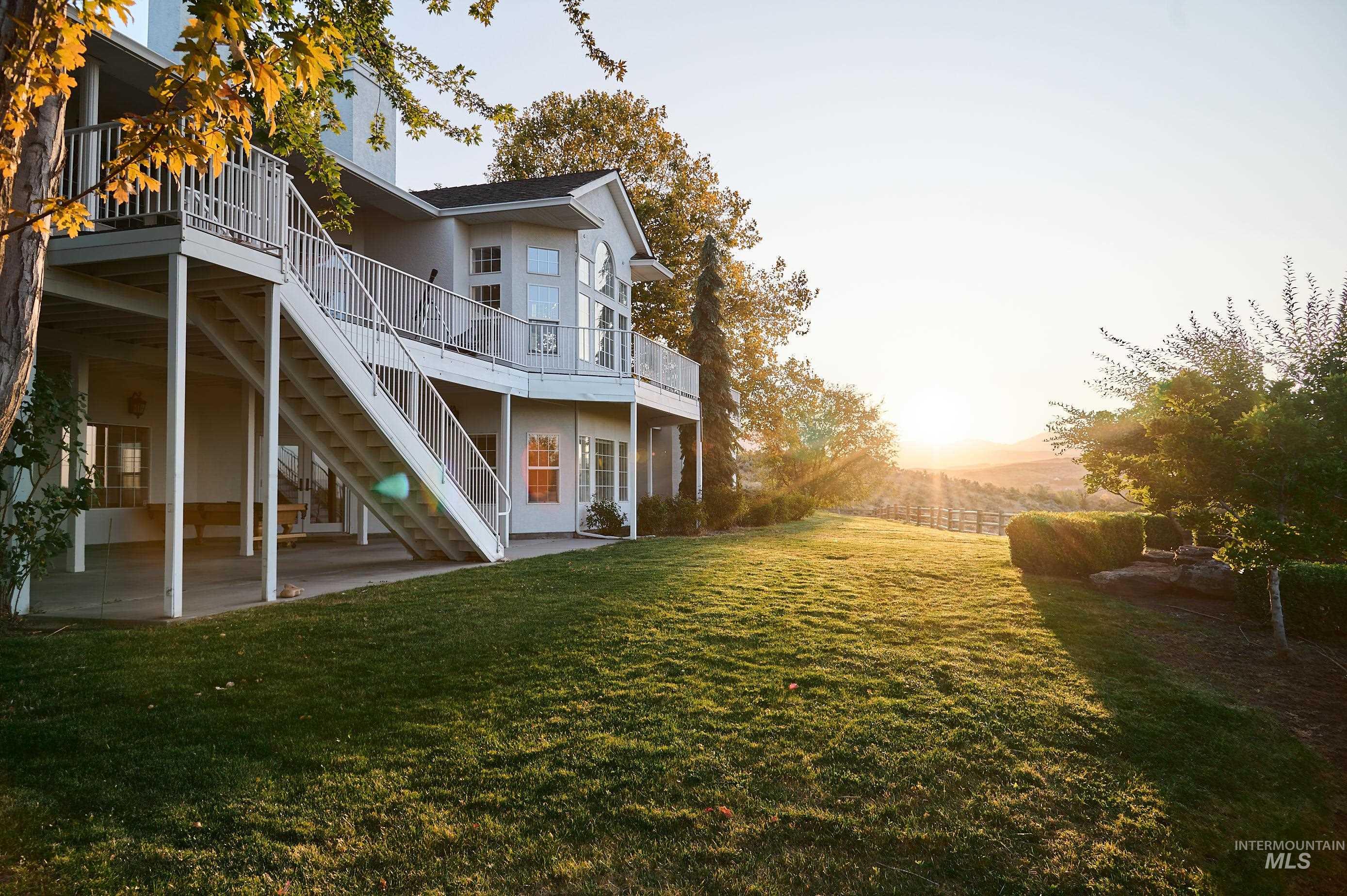 Rear view of house featuring a patio area, stairway, a yard, a wooden deck, and stucco siding