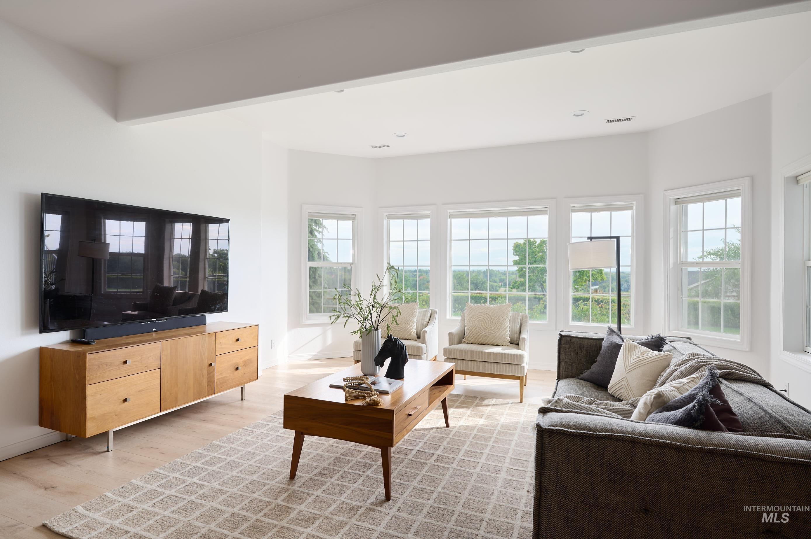 Living area featuring light wood finished floors and recessed lighting