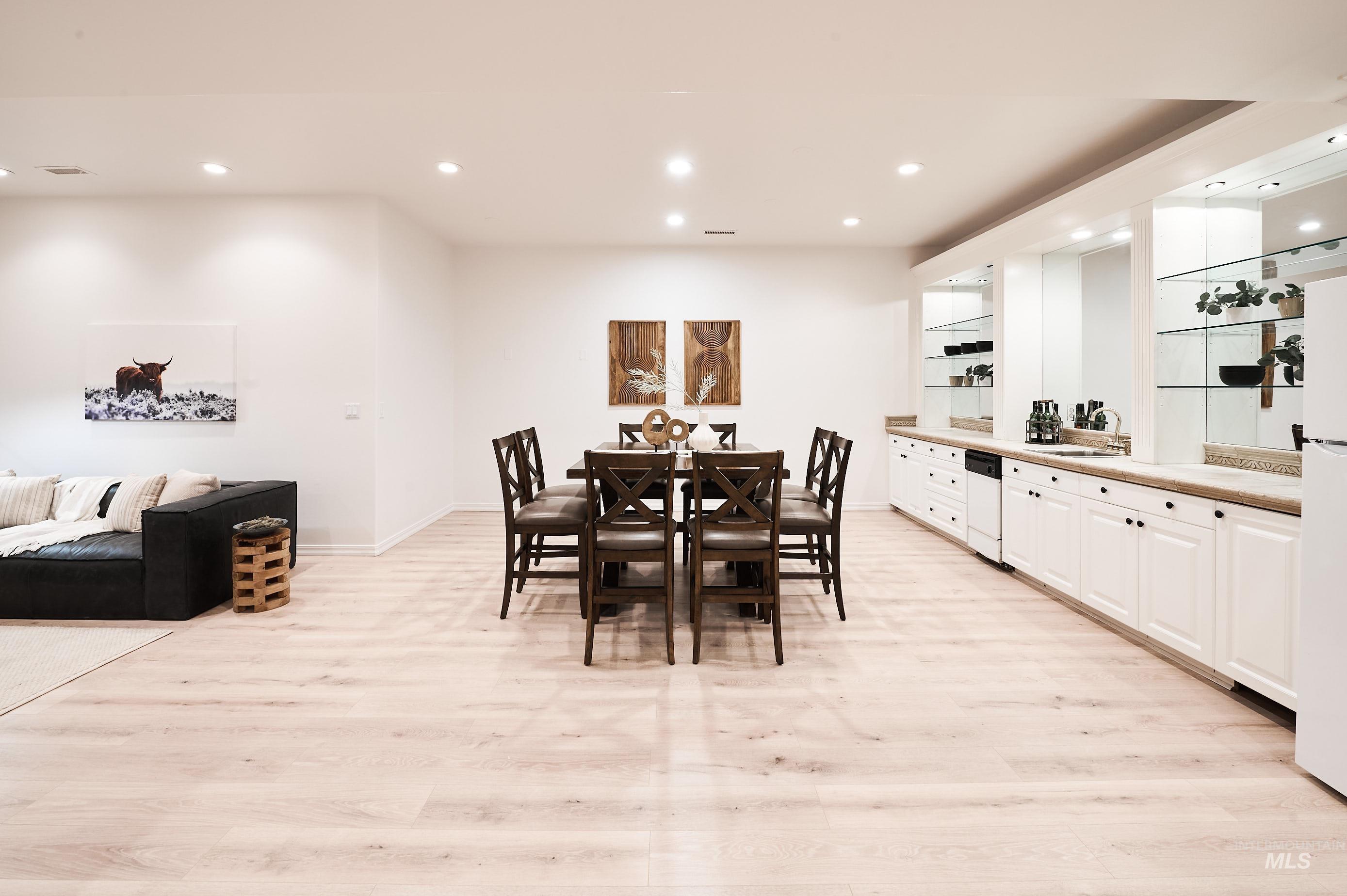 Dining space featuring recessed lighting, light wood-type flooring, and bar area