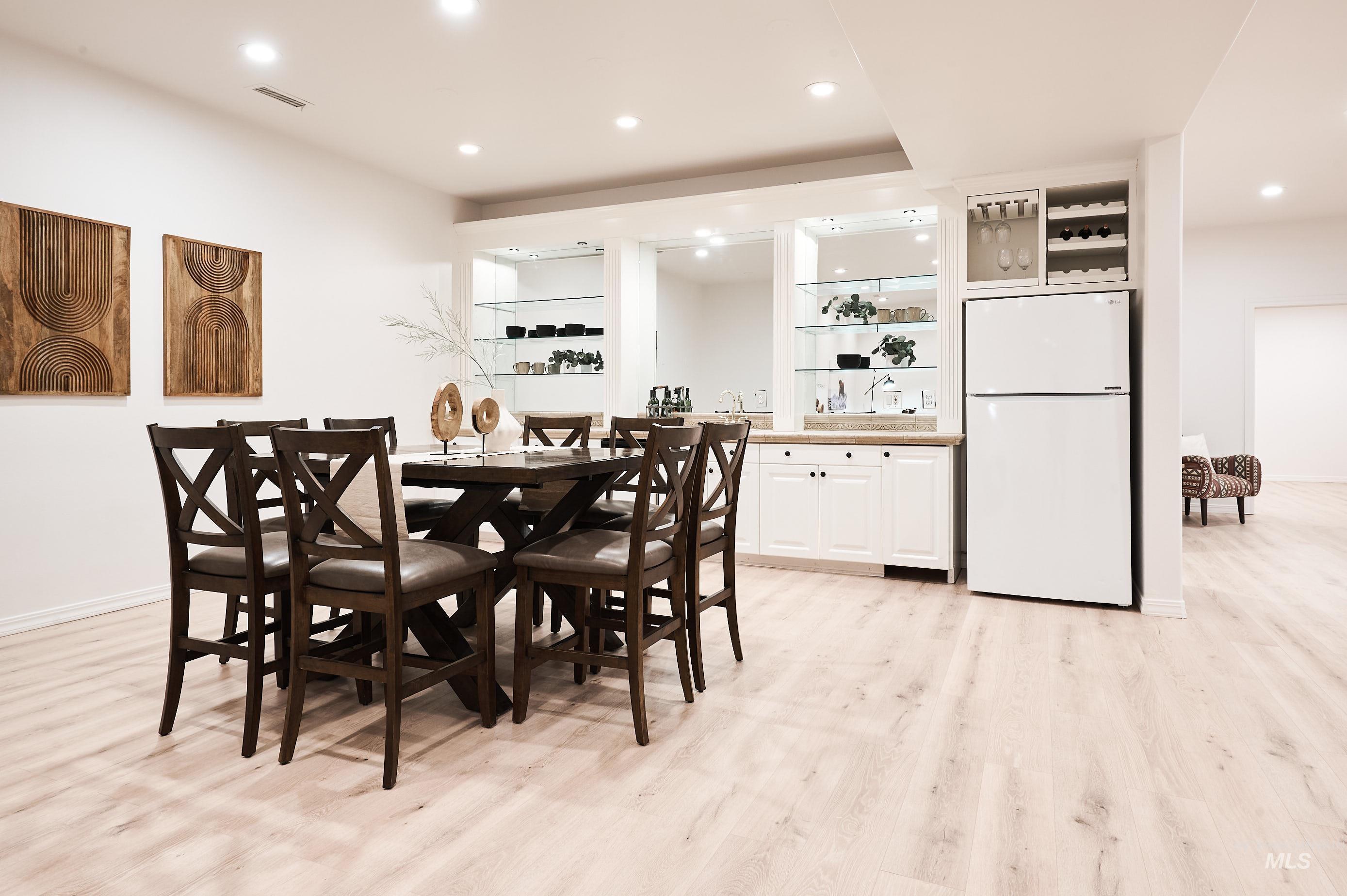 Dining area with recessed lighting and light wood-style flooring