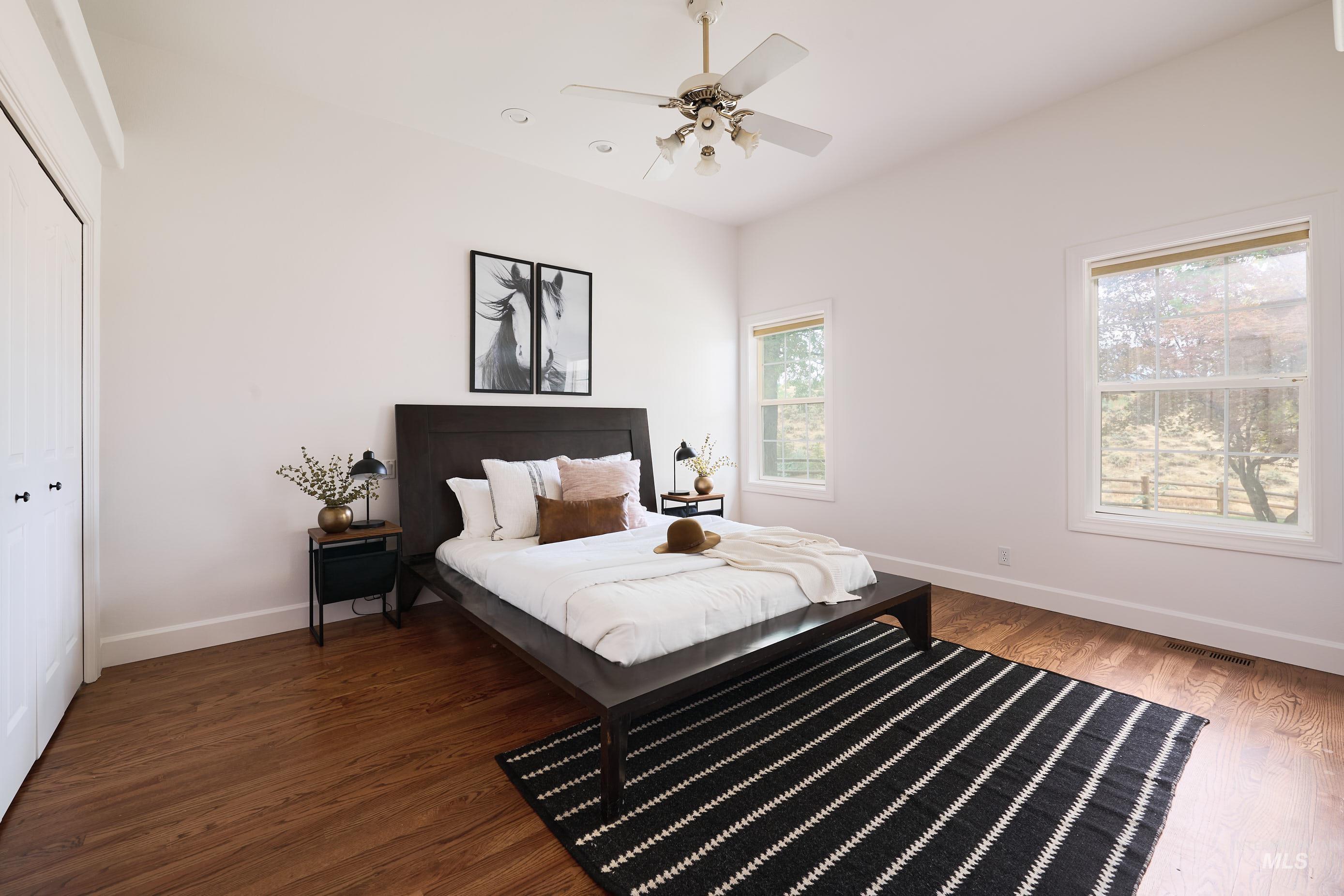 Bedroom featuring a closet, dark wood-style floors, and ceiling fan