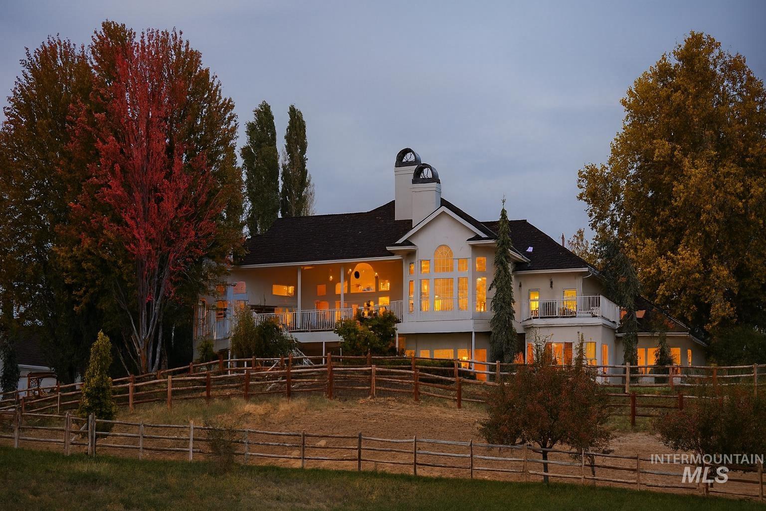 Rear view of house featuring a fenced backyard, a chimney, stucco siding, roof with shingles, and a porch