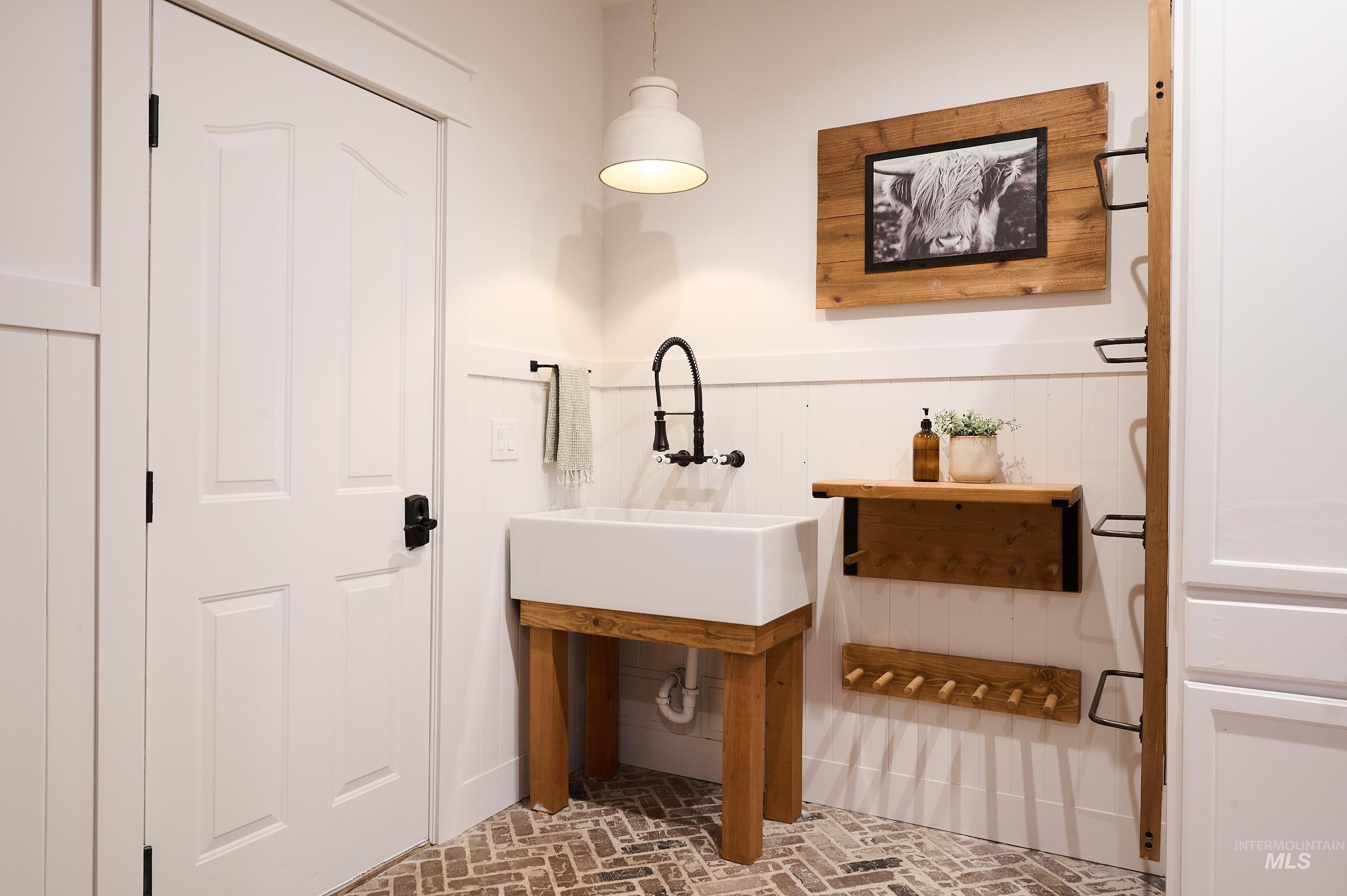 Bathroom featuring brick flooring and a sink