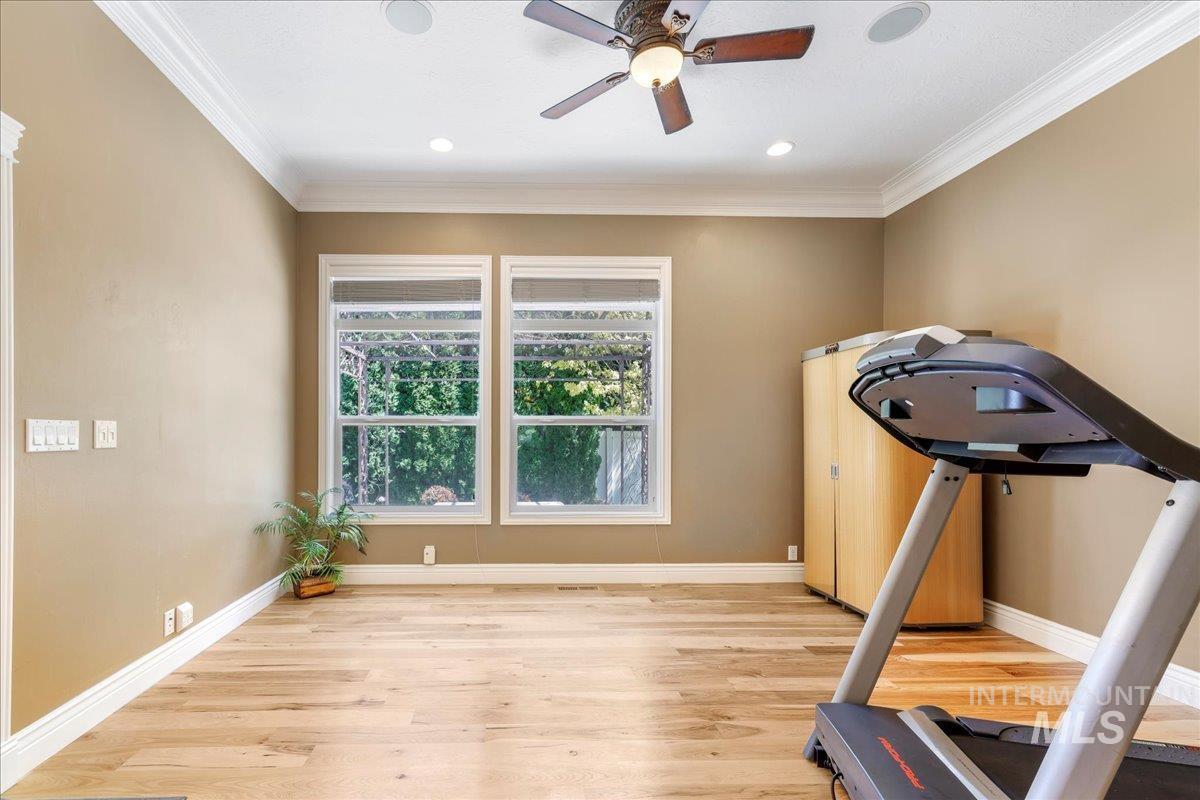 Workout room featuring light wood-type flooring, ornamental molding, a ceiling fan, and recessed lighting