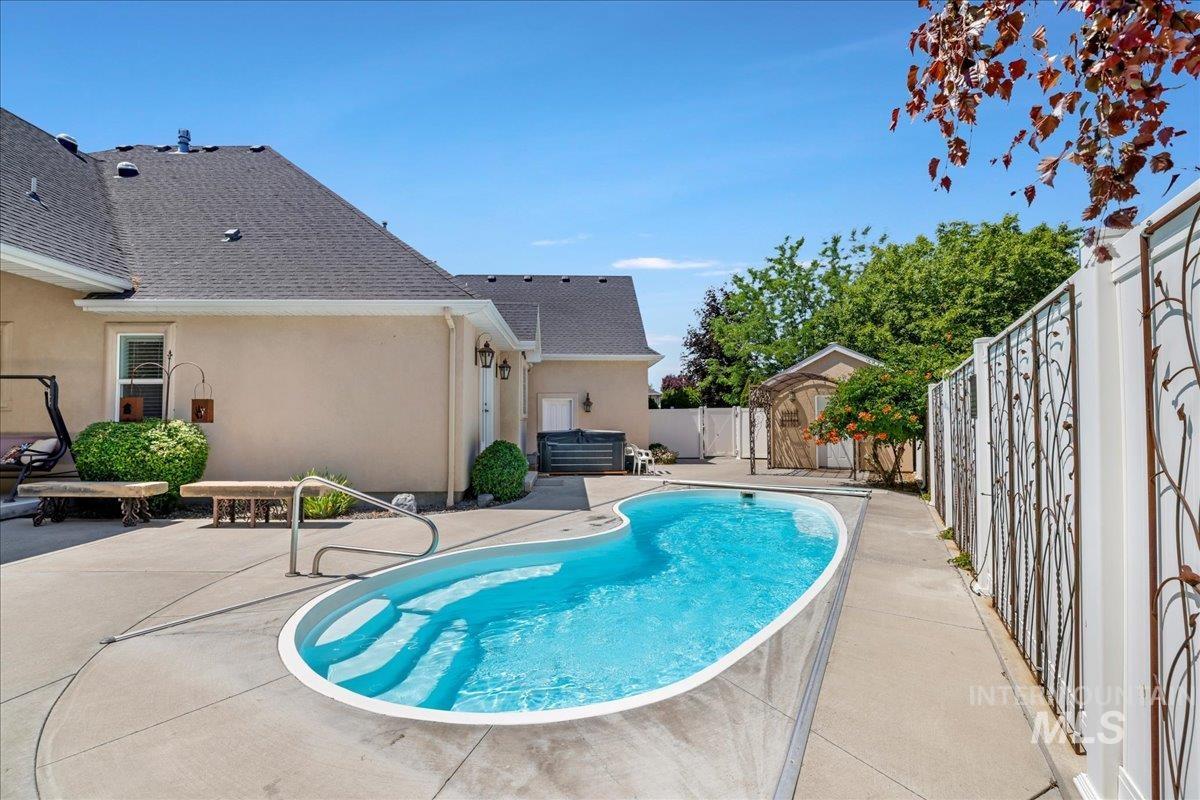 View of swimming pool featuring a patio, a fenced backyard, and a storage shed