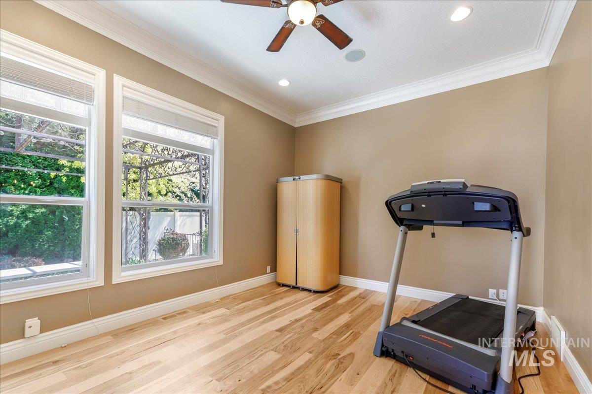 Exercise area featuring wood finished floors, crown molding, ceiling fan, and recessed lighting