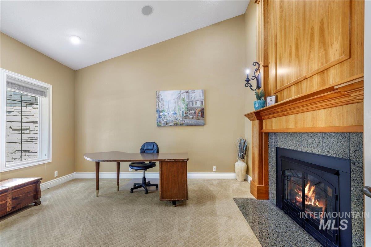 Home office featuring light colored carpet and a fireplace