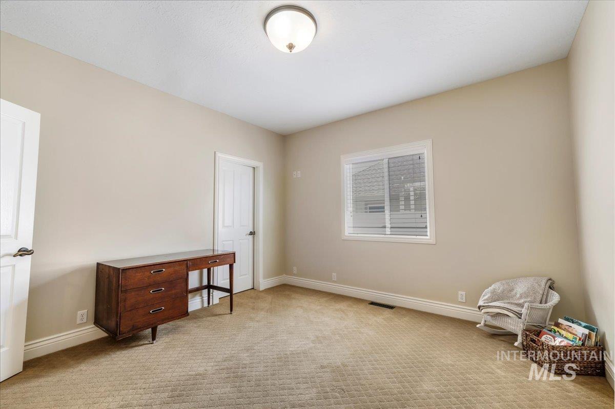 Unfurnished bedroom with baseboards and light colored carpet